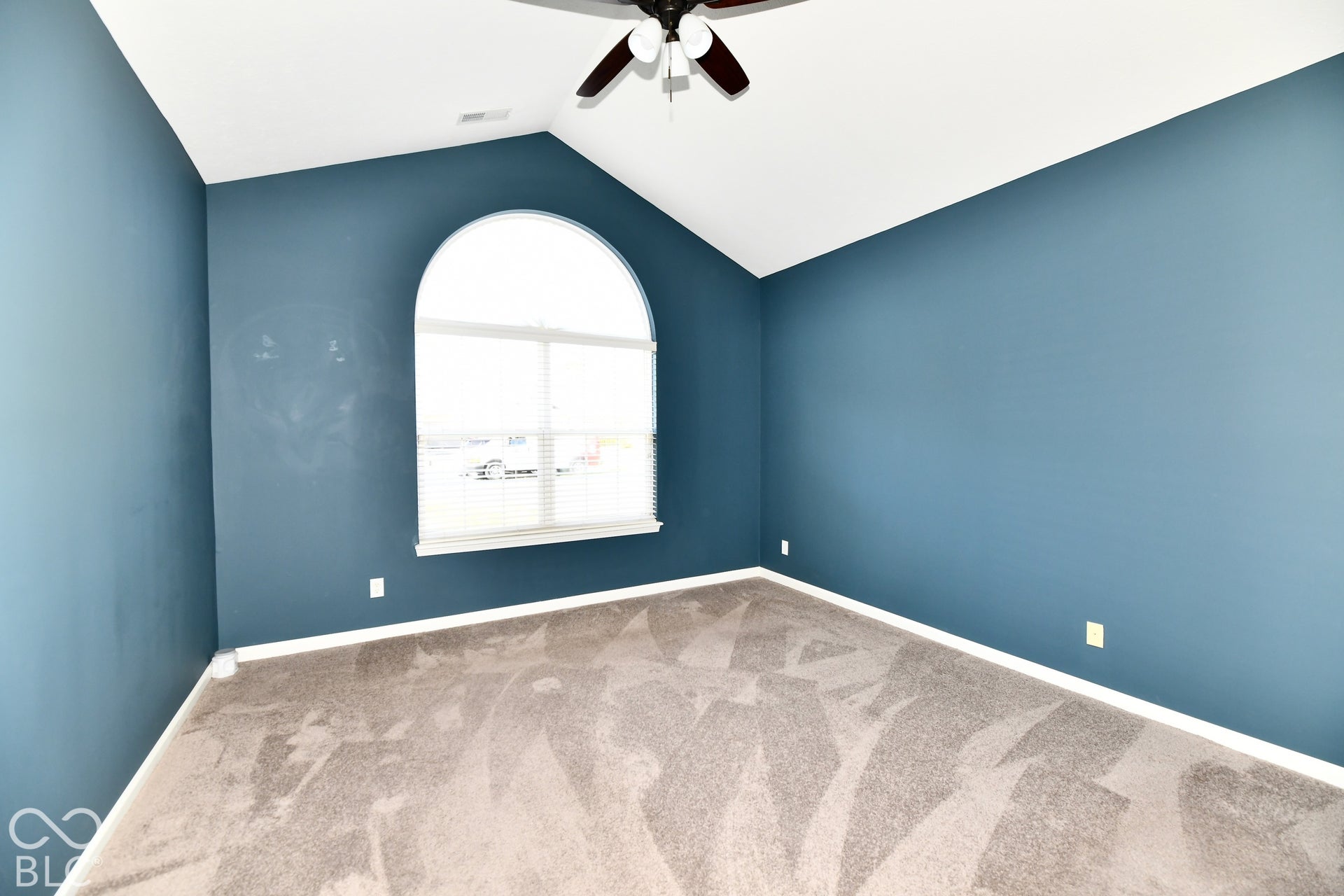 6673 Avila Way, Fishers, IN 46038 Vaulted ceiling with a ceiling fan, arched window with blinds, and neutral carpet flooring