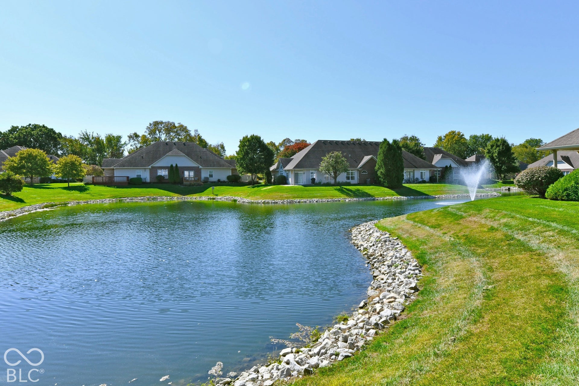 6673 Avila Way, Fishers, IN 46038 Expansive water feature with a fountain, surrounded by manicured lawns and mature trees