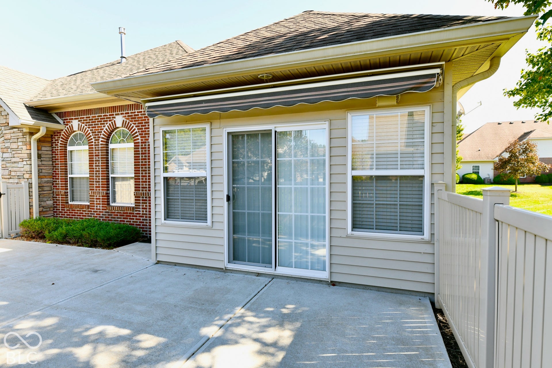 6673 Avila Way, Fishers, IN 46038 Concrete patio with a retractable awning, siding, and a sliding glass door