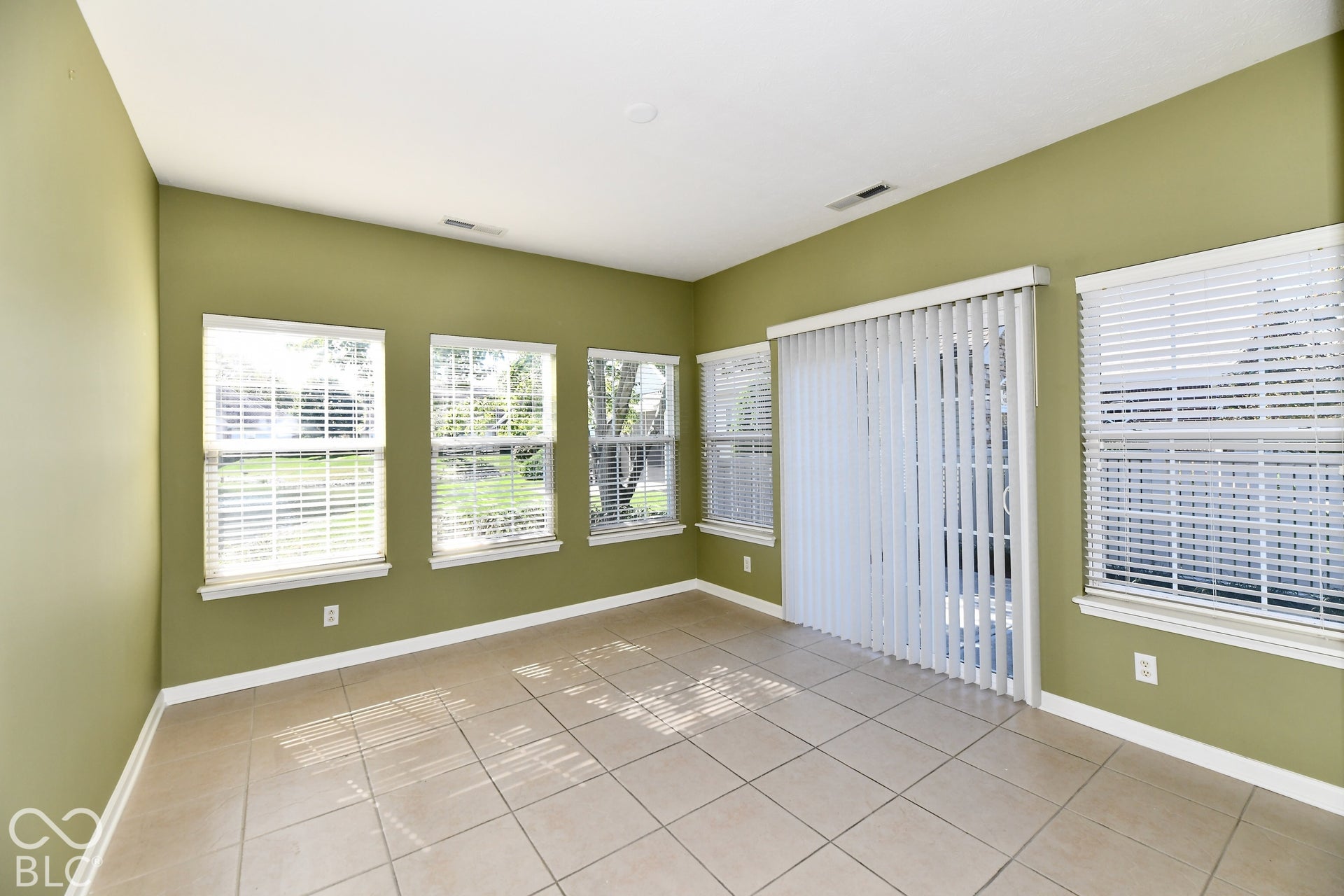 6673 Avila Way, Fishers, IN 46038 Ceramic tile flooring, multiple windows with blinds, sliding glass door with vertical blinds, and recessed lighting