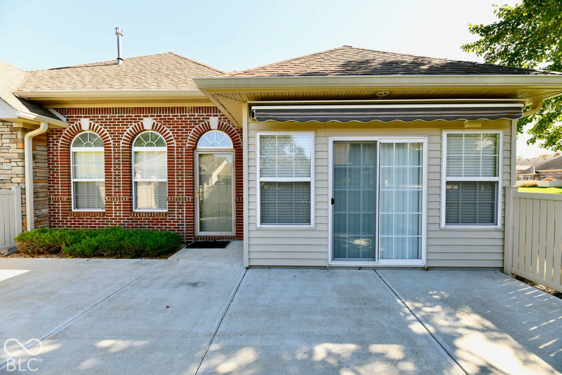 6673 Avila Way, Fishers, IN 46038 Expansive concrete patio with a retractable awning, siding exterior, and sliding glass door