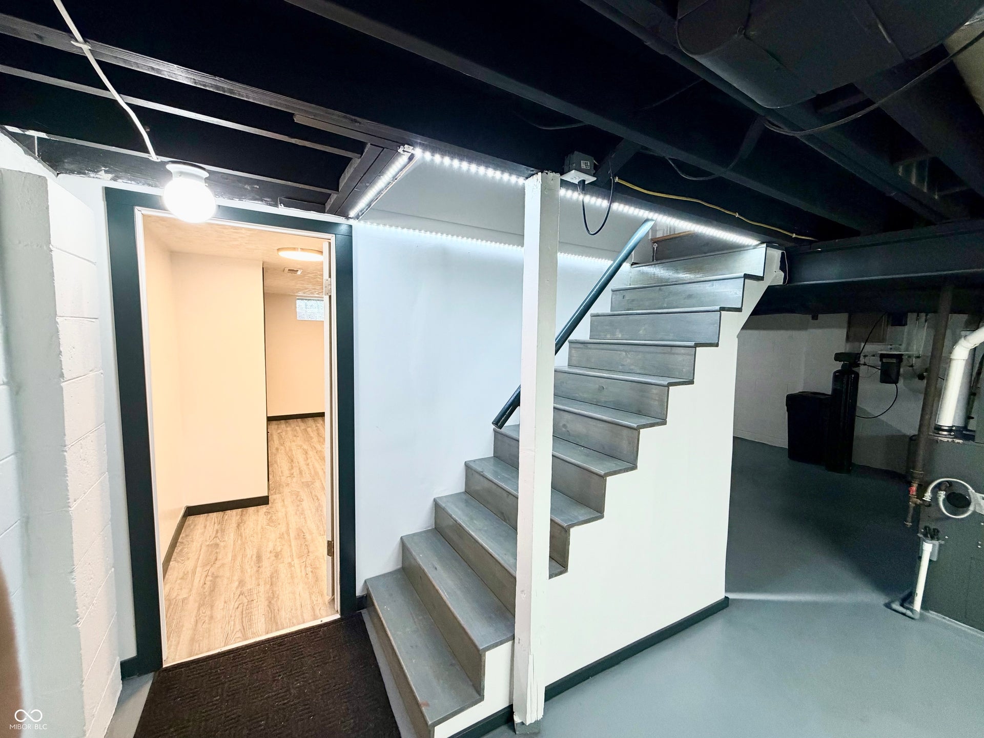 6314 N Keystone Avenue, Indianapolis, IN 46220 Staircase featuring wood-finish treads, black handrail, and integrated strip lighting