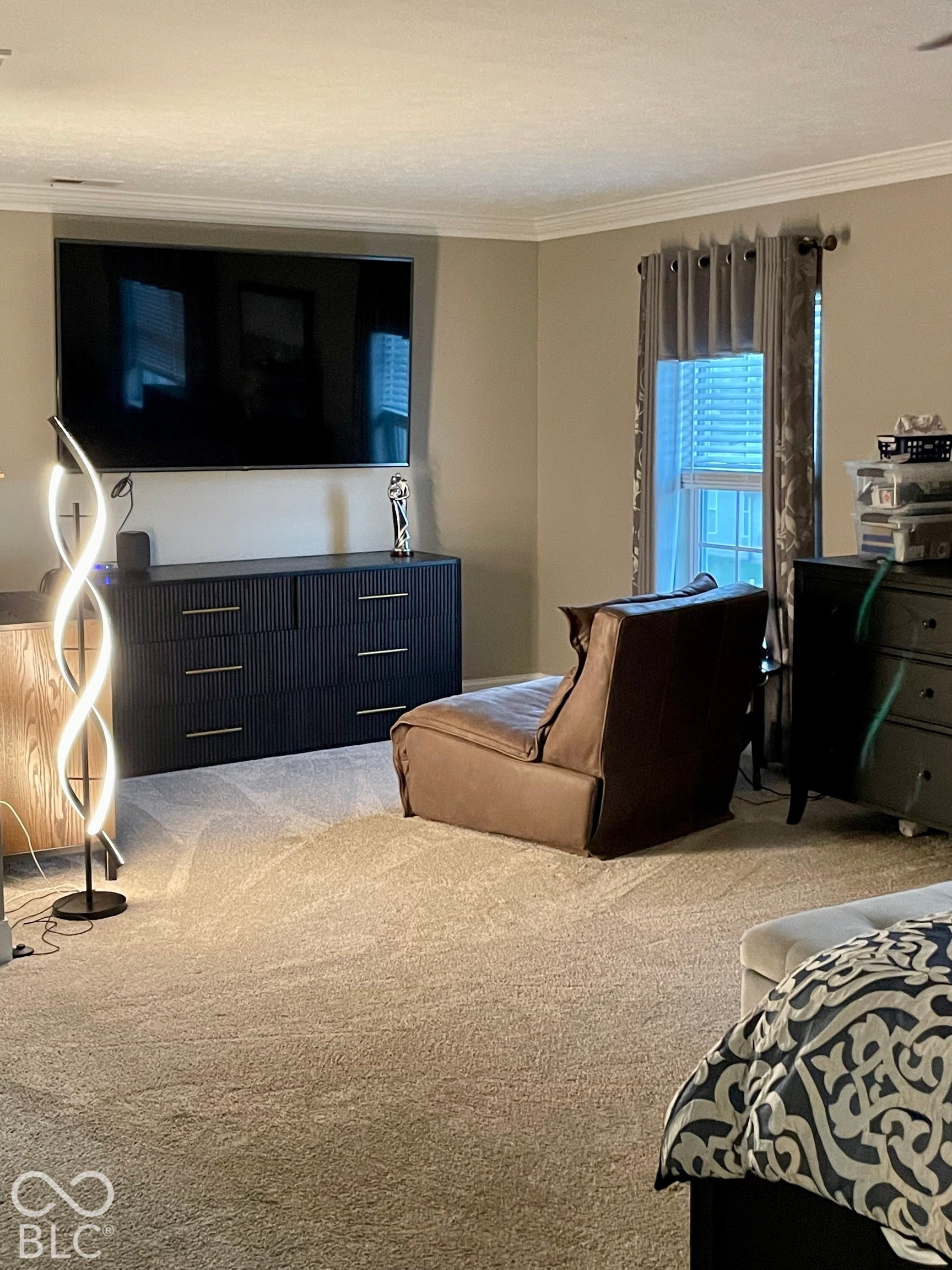 Primary Bedroom sitting area with crown molding, neutral carpeting, and window with blinds