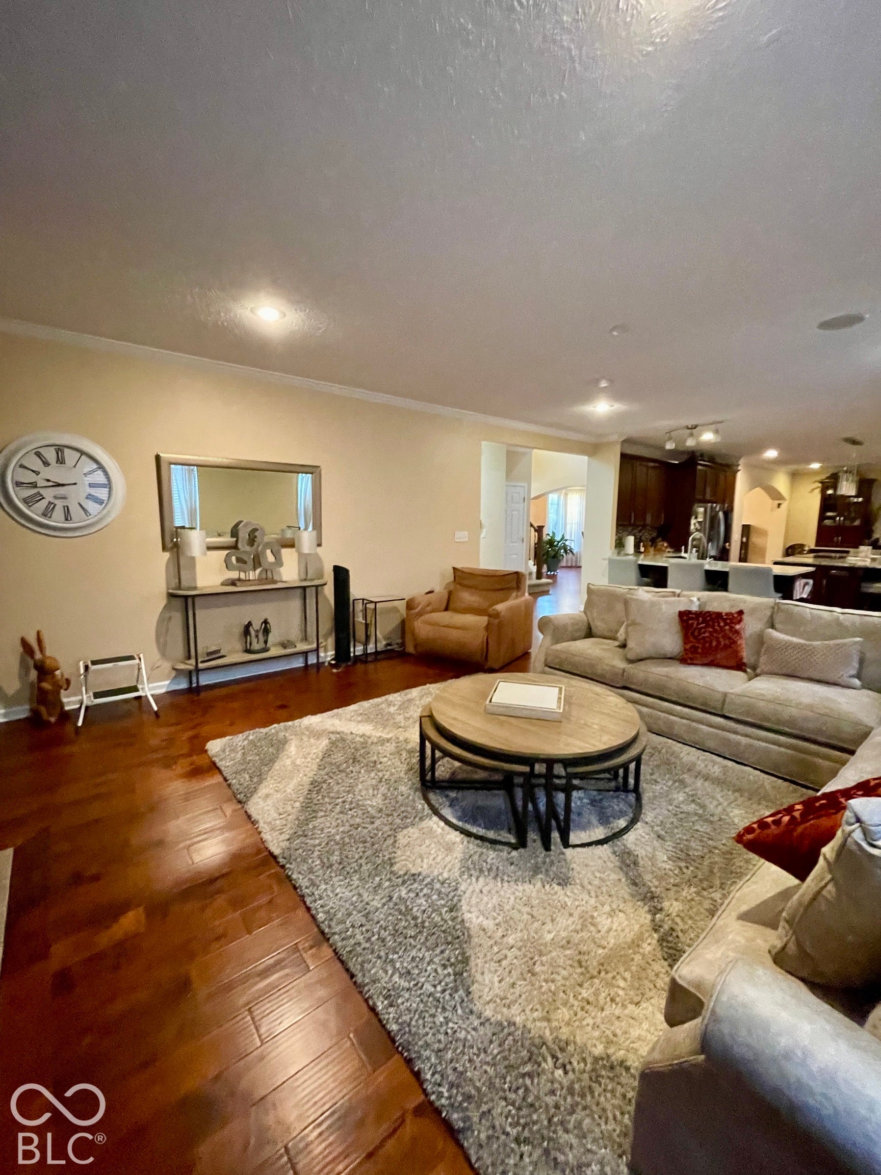 Wood-finish flooring throughout, recessed ceiling lighting, and crown molding
