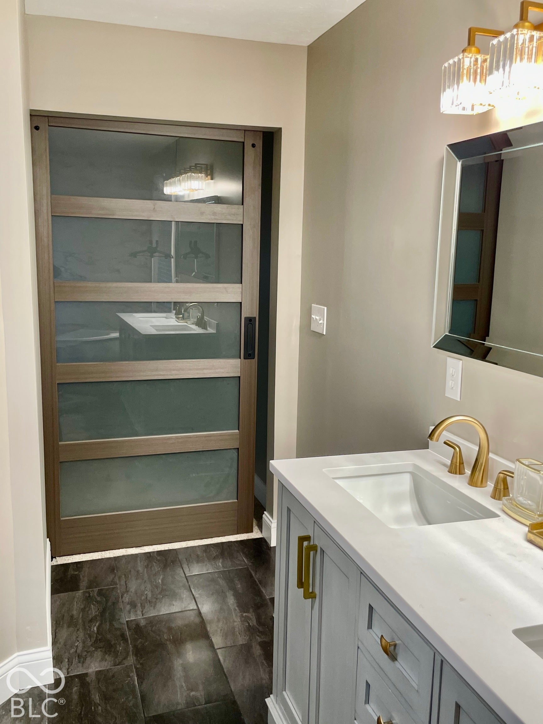 Light-toned vanity with an integrated sink and gold-tone faucet