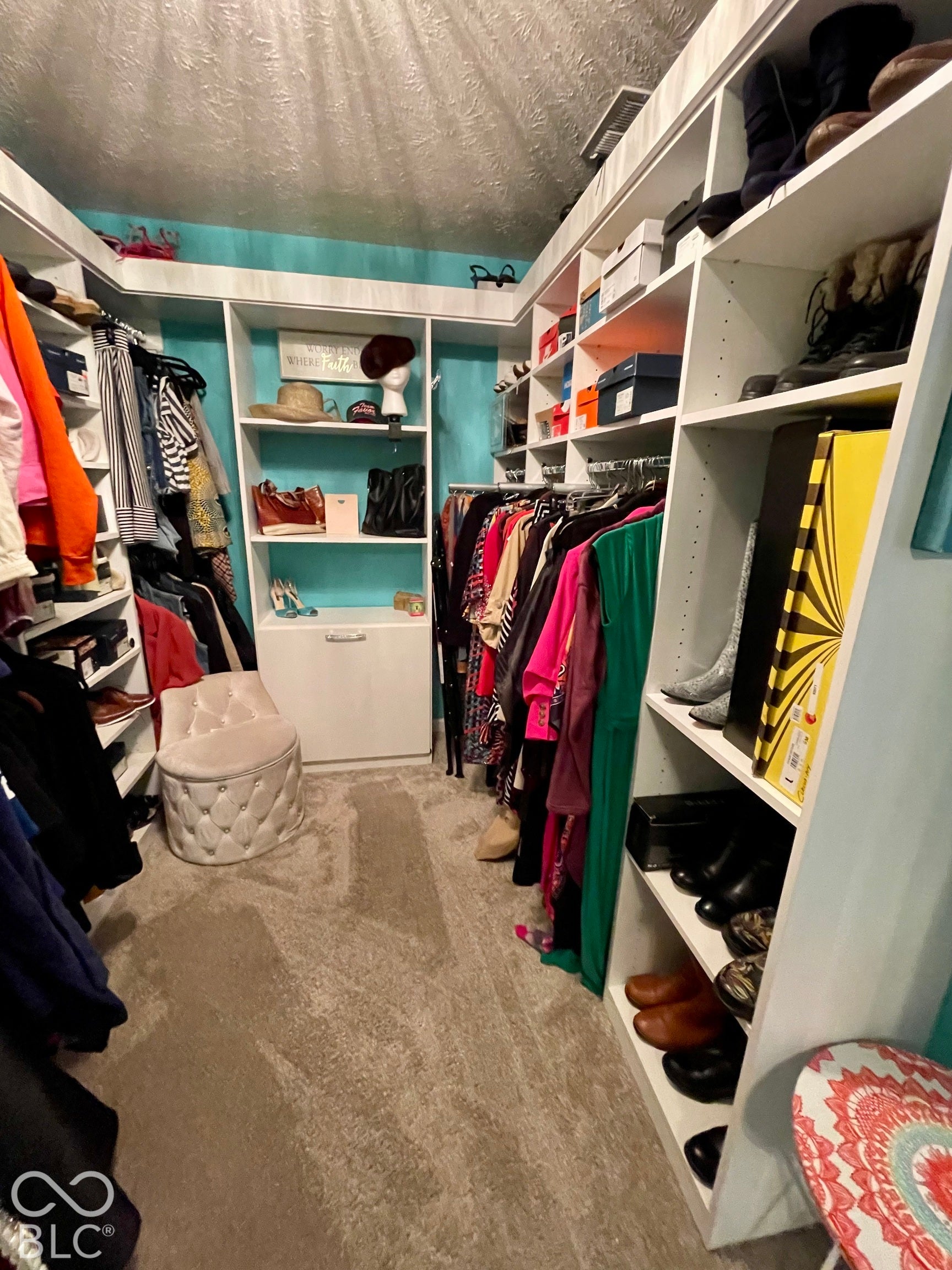 Built-in custom California Closet, integrated hanging rods, and light-colored carpeting in Primary Bath