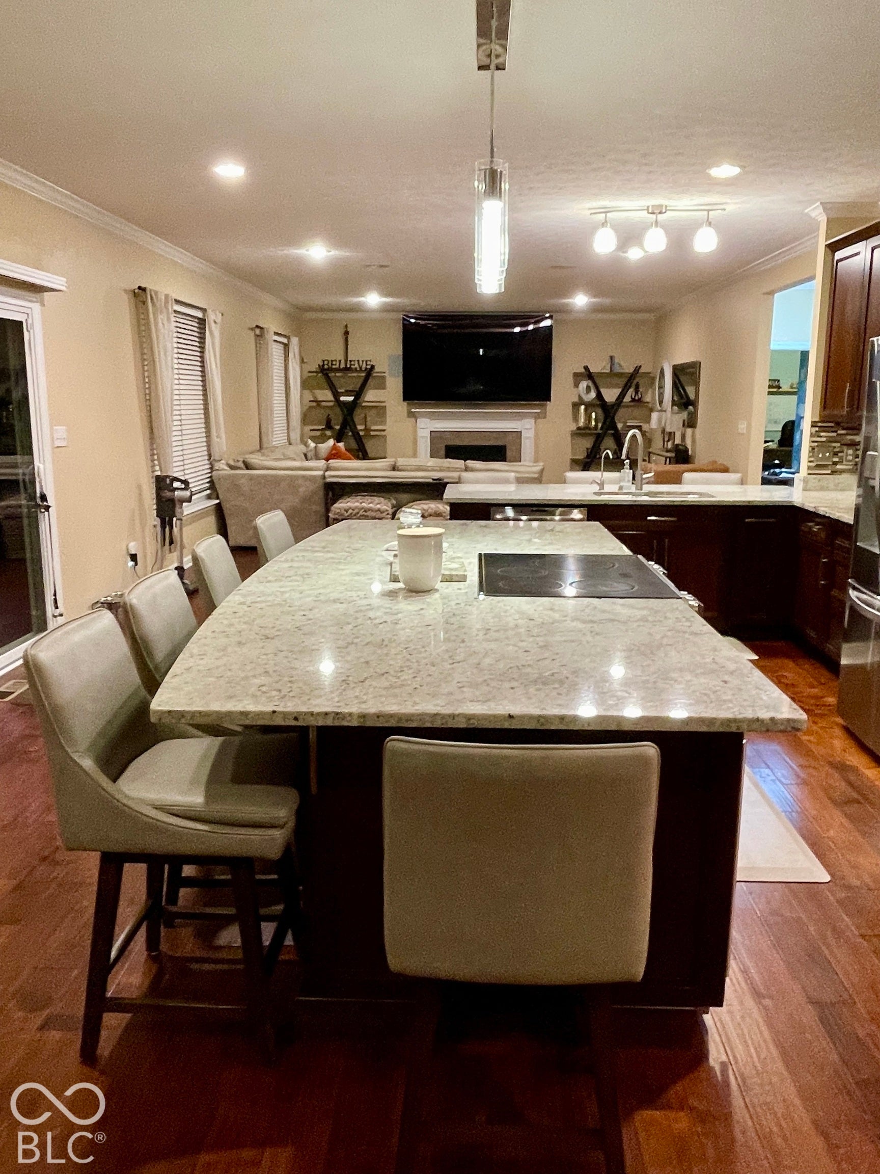 Spacious kitchen island with an integrated cooktop and granite countertop