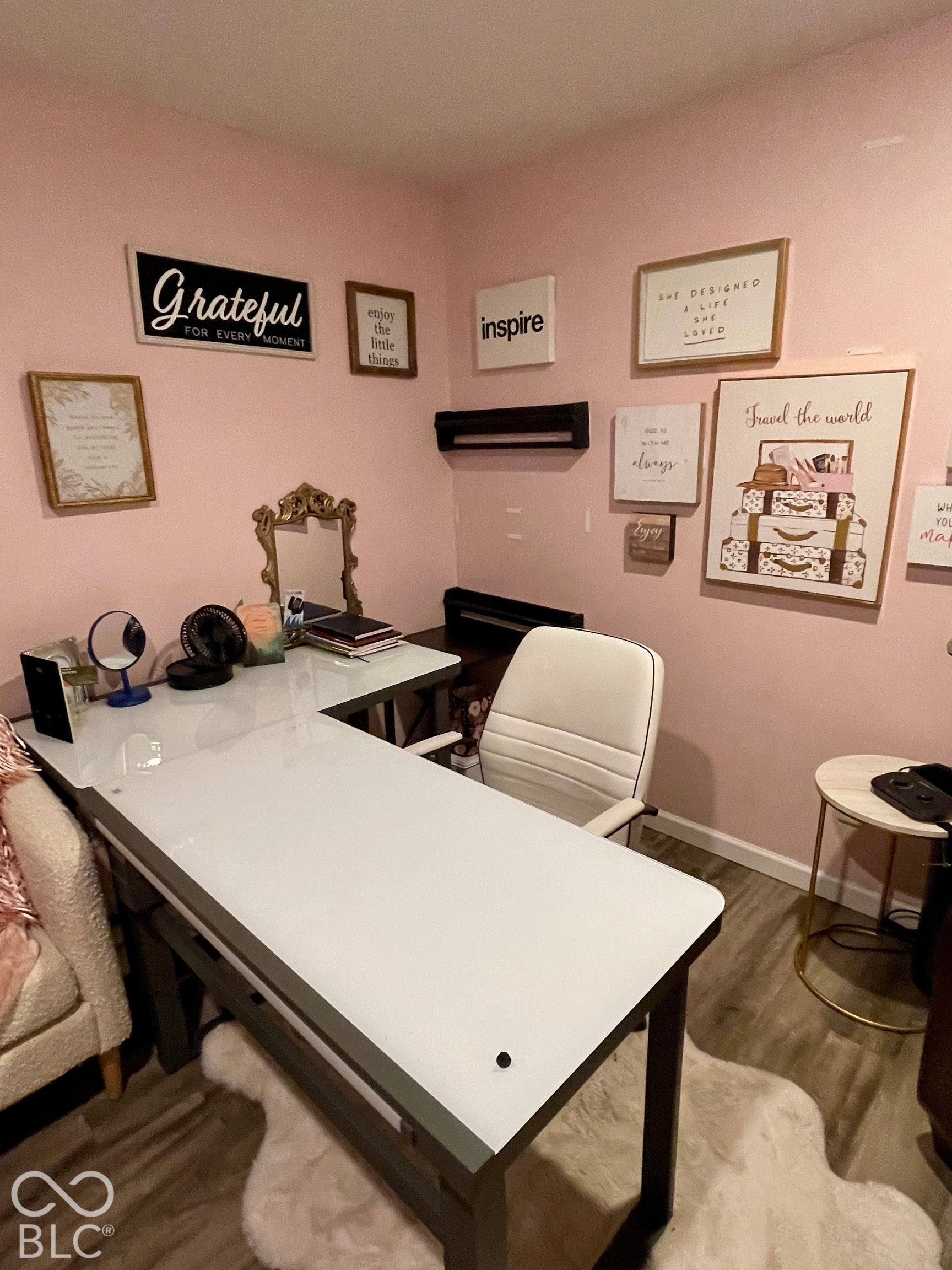 L-shaped desk with a light-colored surface, wood-finish flooring, and a small built-in shelf
