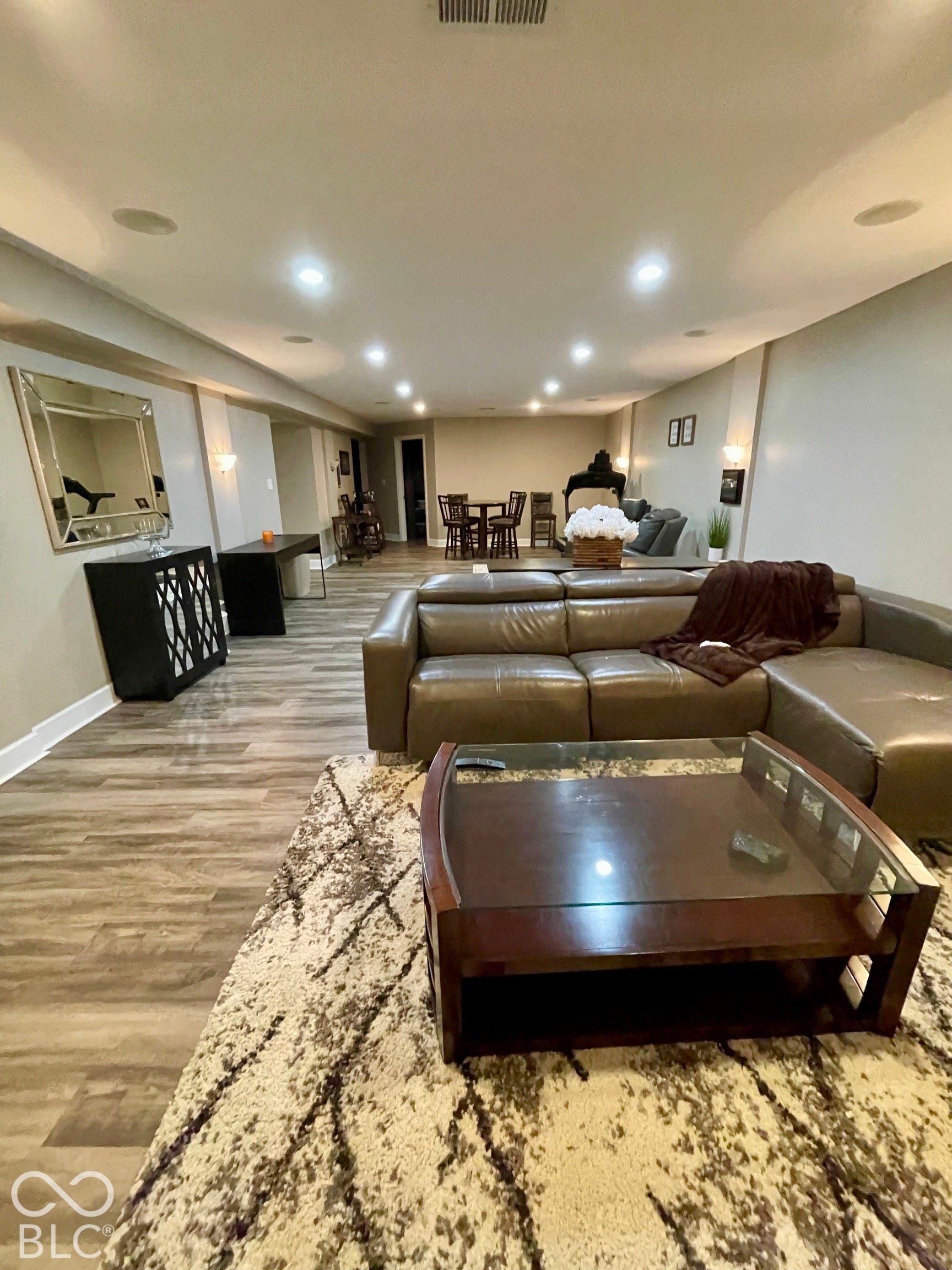 Recessed lighting throughout a spacious room with wood-finish flooring
