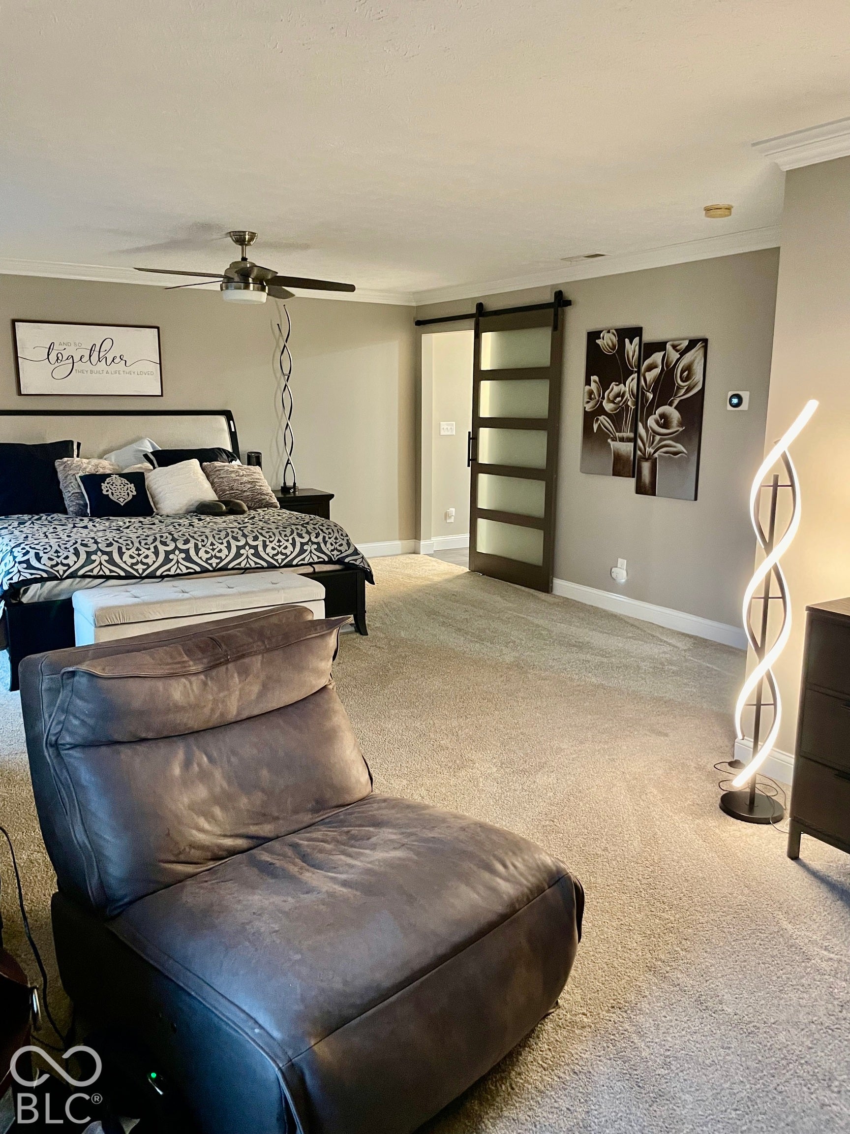 Neutral wall color with crown molding, ceiling fan with integrated lighting, and carpet flooring