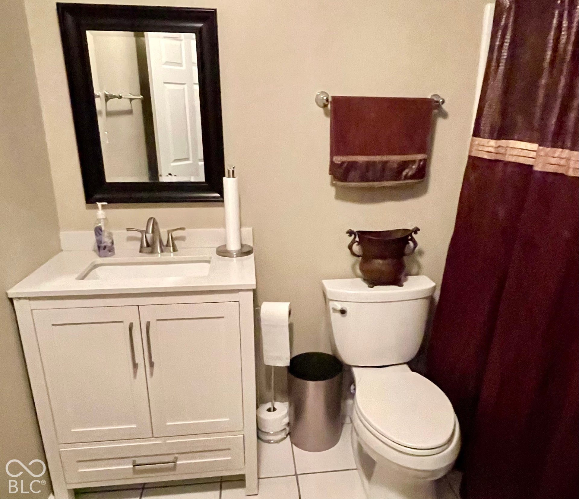 White vanity with dual-door cabinet and lower drawer, integrated sink, and chrome faucet