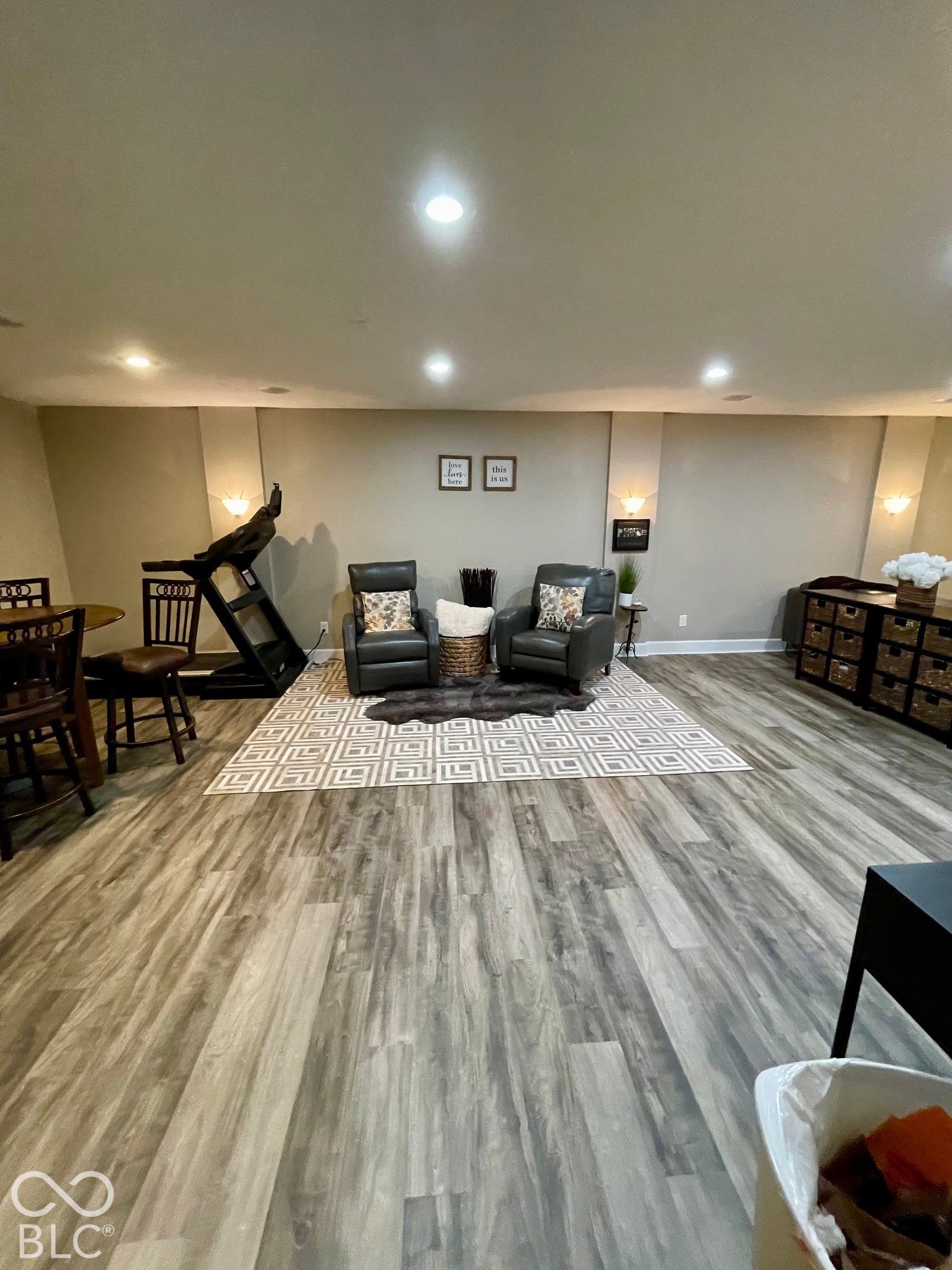 Recessed lighting and wood-finish flooring define this expansive room