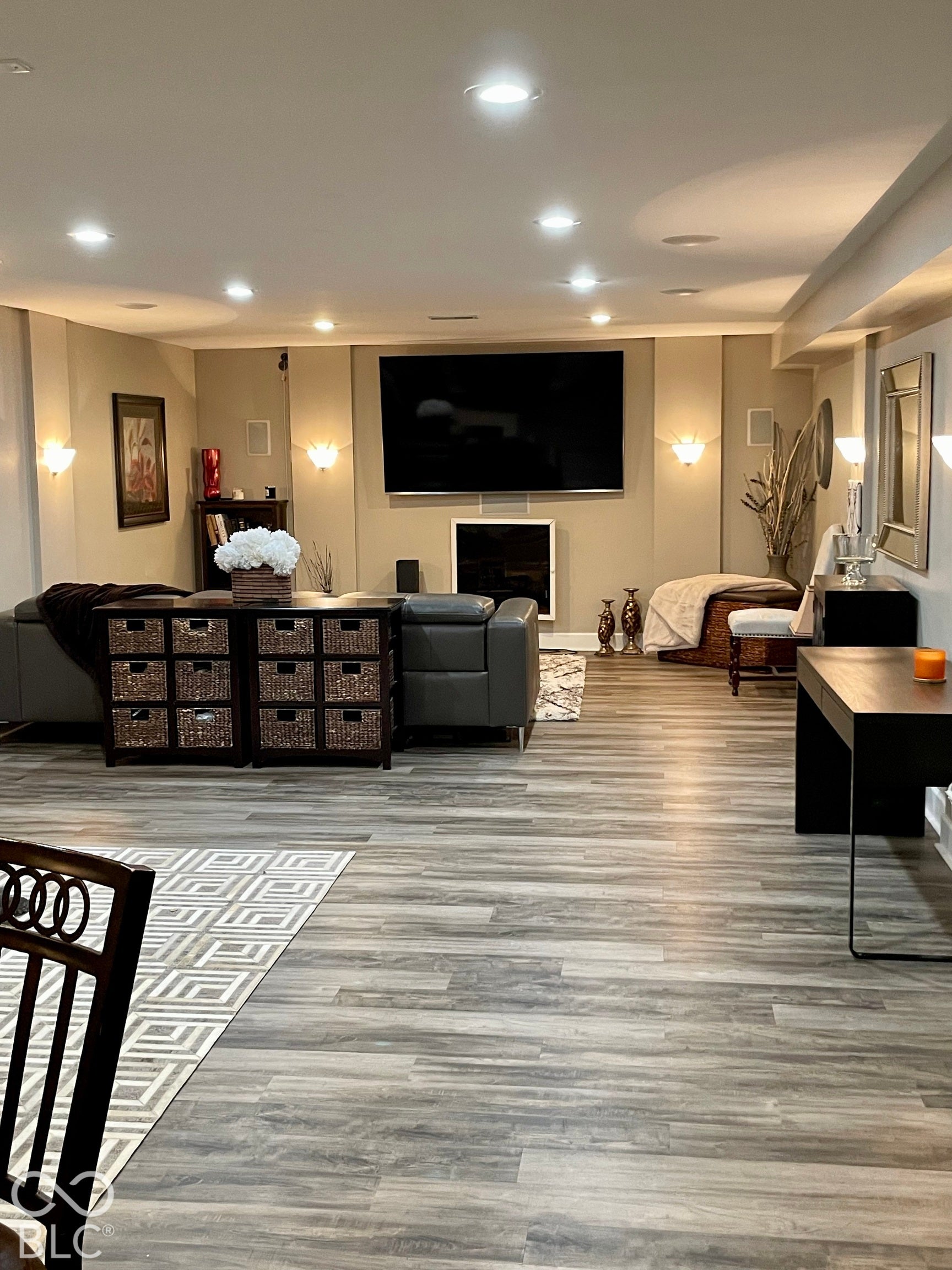 Spacious room featuring recessed lighting, wood-finish flooring, a wall-mounted television, and a built-in fireplace