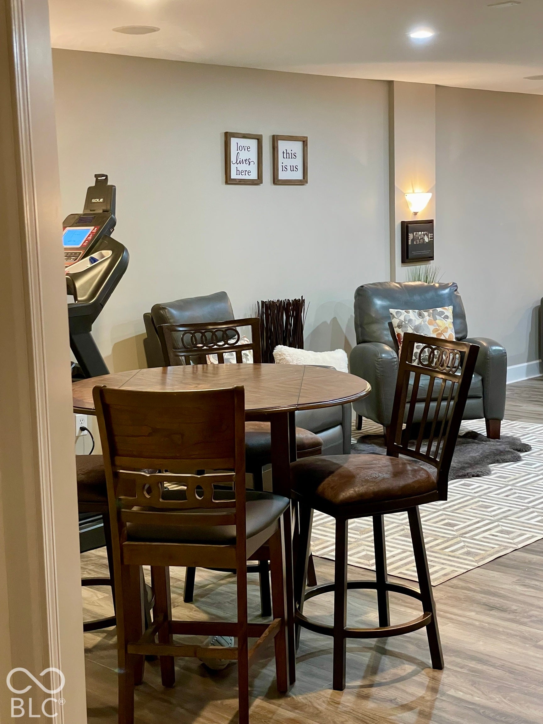 Recessed ceiling lighting, wall-mounted sconce lighting, wood-finish flooring, and painted walls