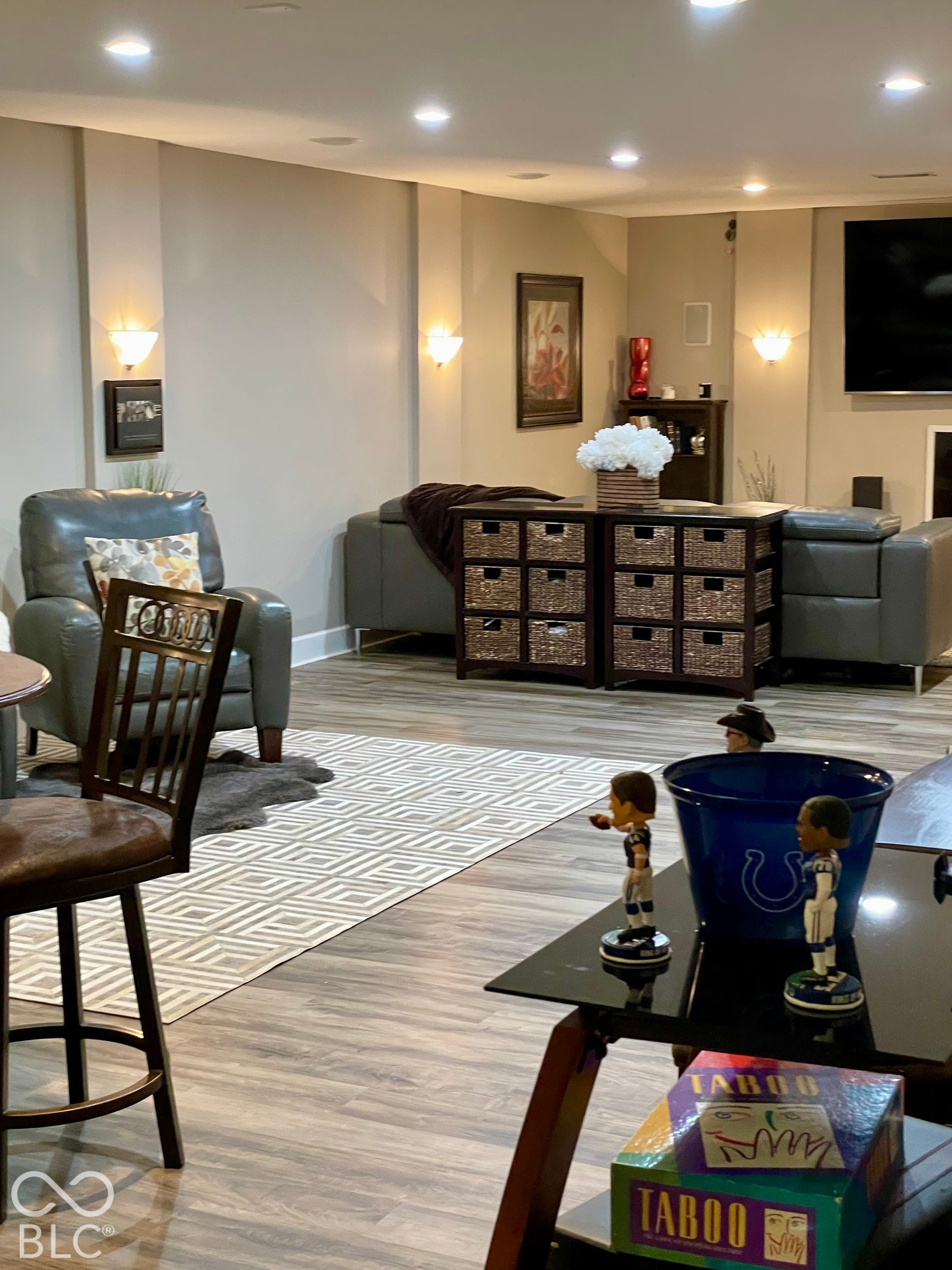 Recessed ceiling lighting, wall-mounted sconces, and wood-finish flooring