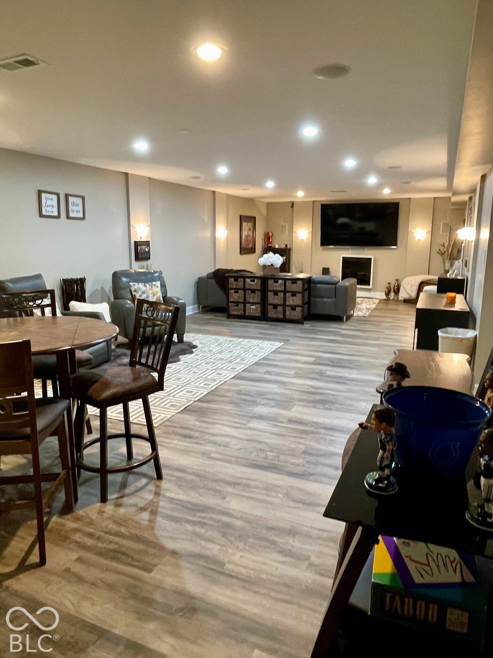 Spacious room featuring wood-finish flooring, recessed lighting, and wall sconces