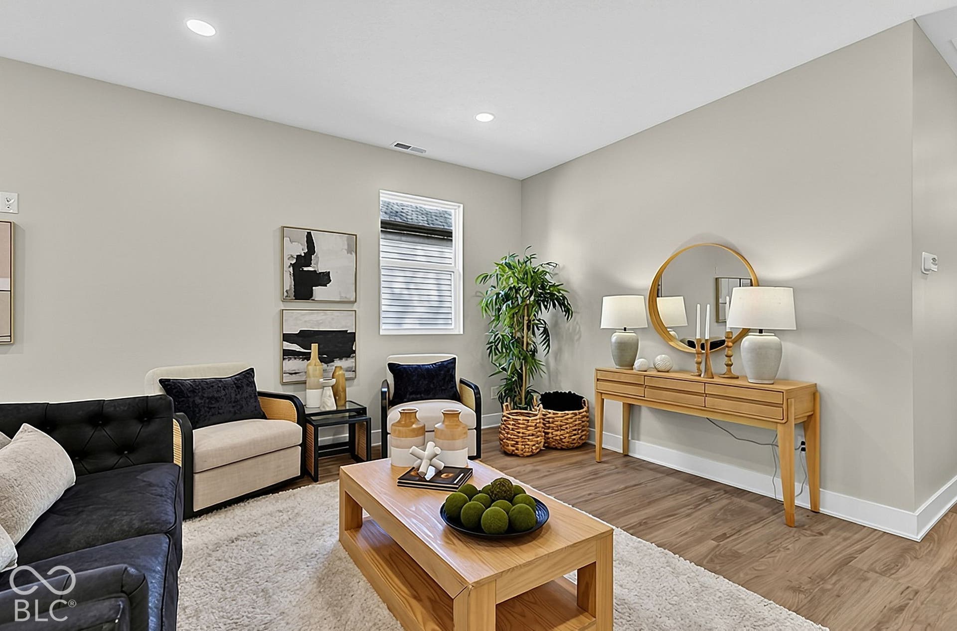 Neutral-toned interior featuring wood-finish flooring, recessed lighting, and a window with white casing