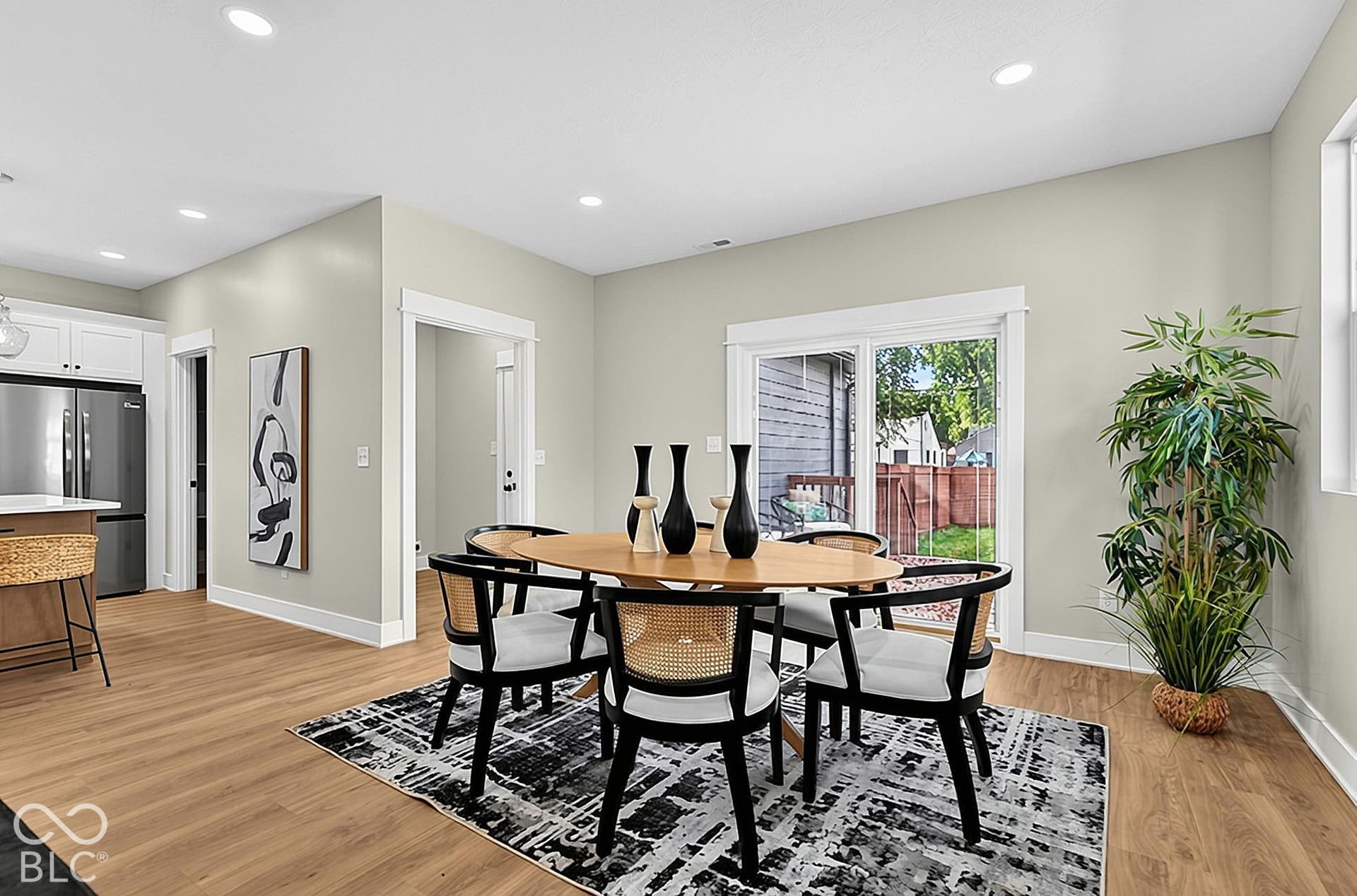 Open-concept interior featuring light wood-finish flooring, recessed lighting, and sliding glass doors