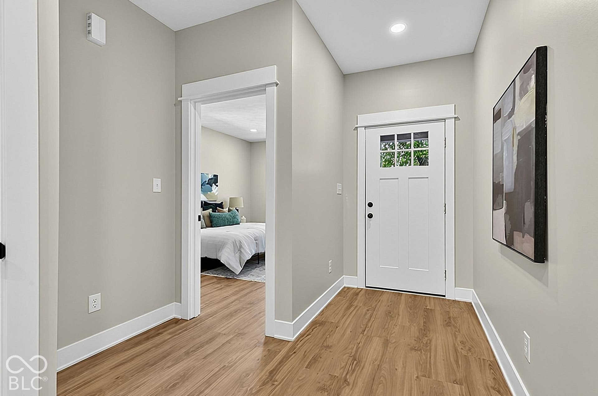 Entryway featuring wood-finish flooring, white door with an upper glass pane, recessed lighting, and crisp white door casings