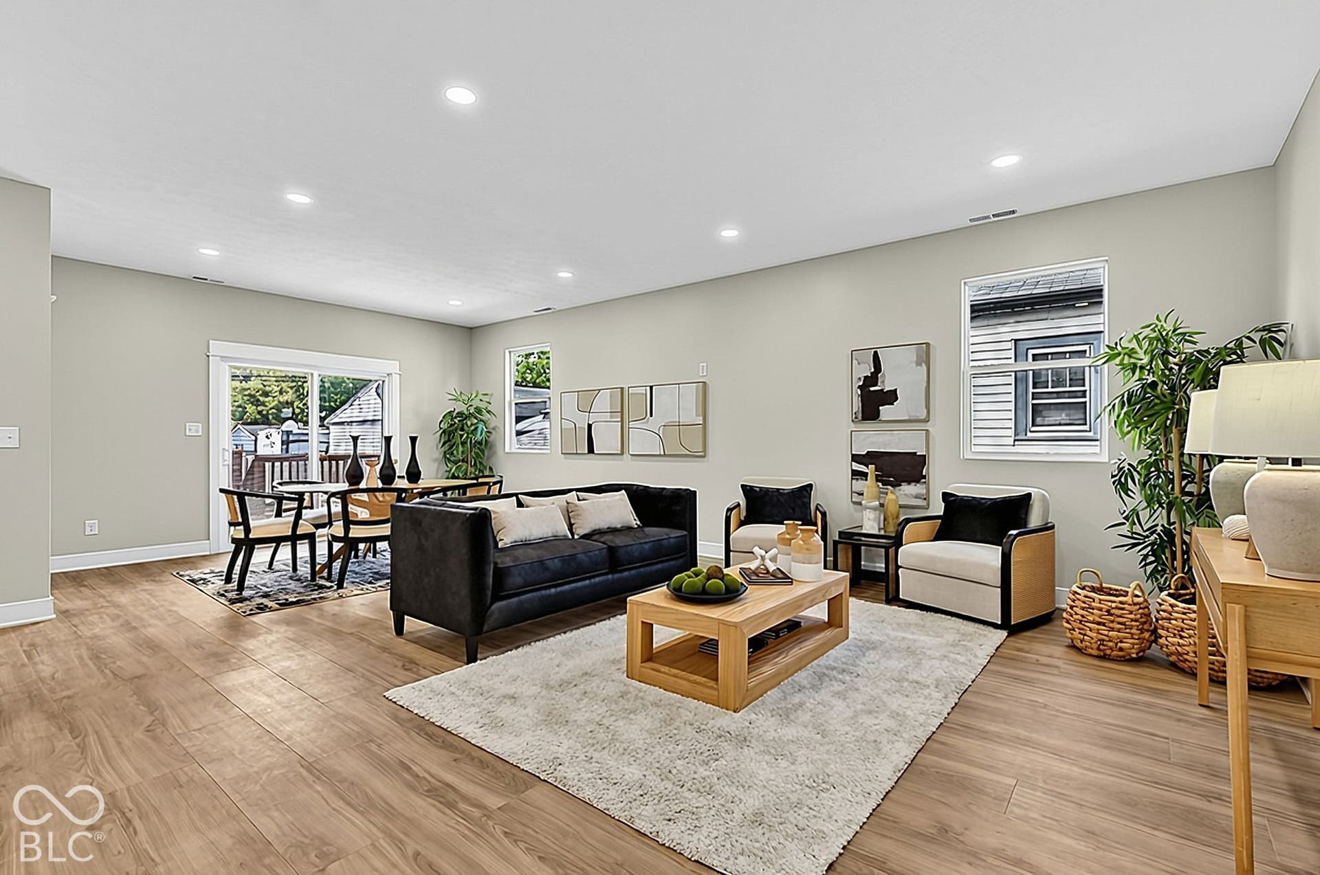 Open-concept interior featuring wood-finish flooring, recessed lighting, neutral wall tones, and sliding glass doors