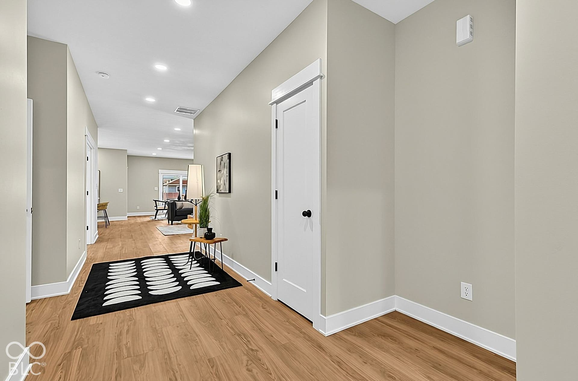 Neutral-toned walls paired with wood-finish flooring, recessed lighting, and interior doors featuring matte black hardware