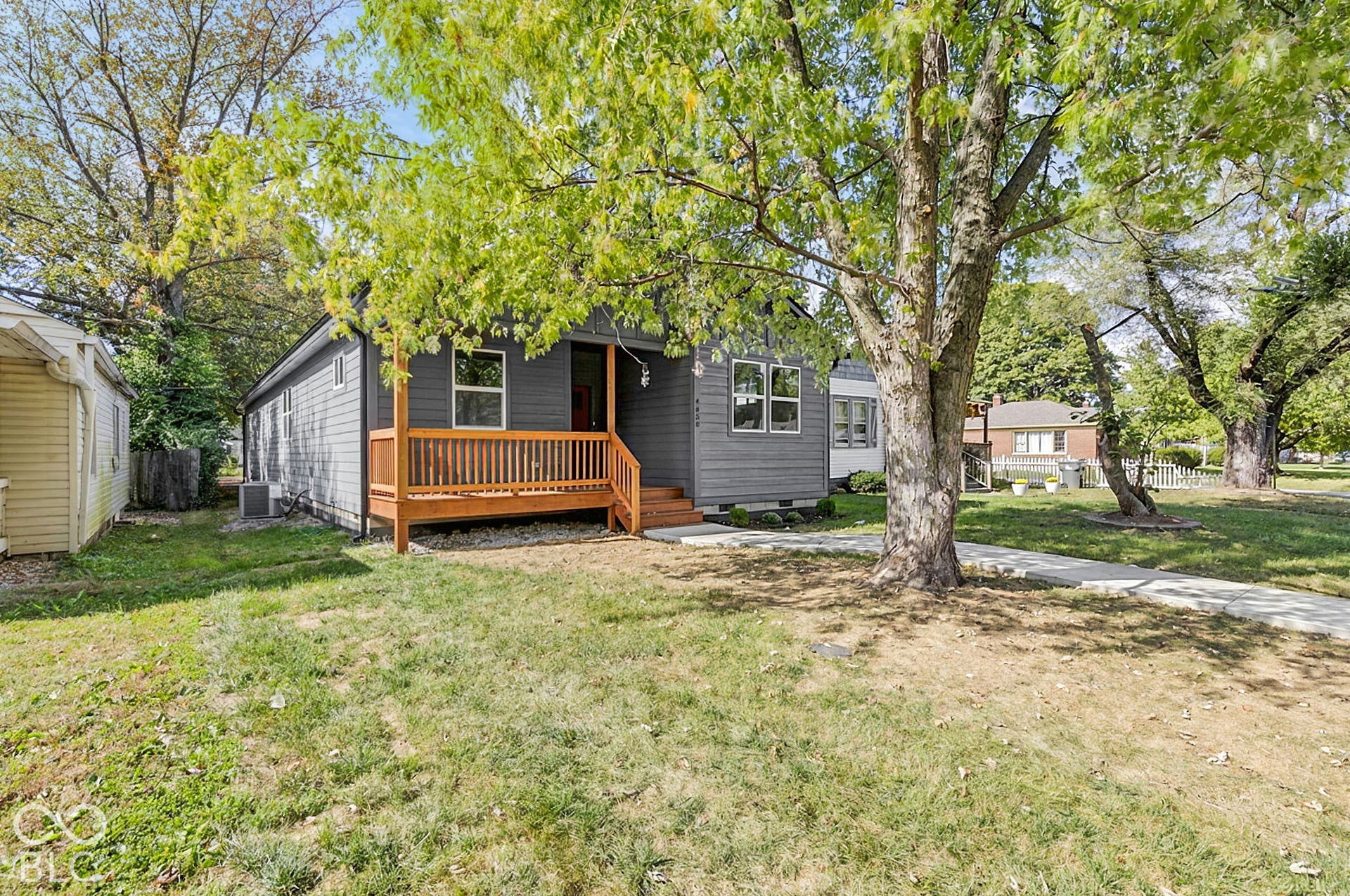 Exterior featuring horizontal lap siding, a front wooden deck with railings, and a concrete walkway