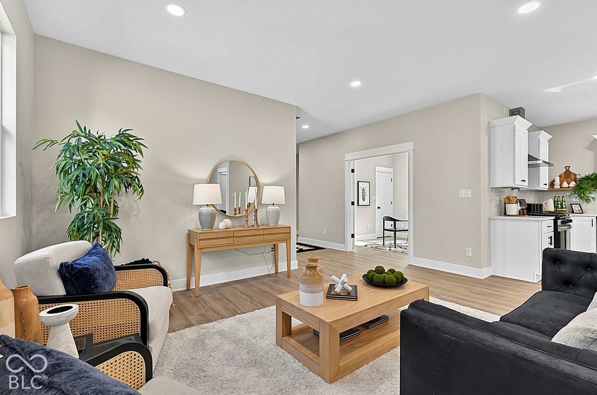 Neutral wall tones with wood-finish flooring, recessed lighting, and white shaker-style kitchen cabinetry