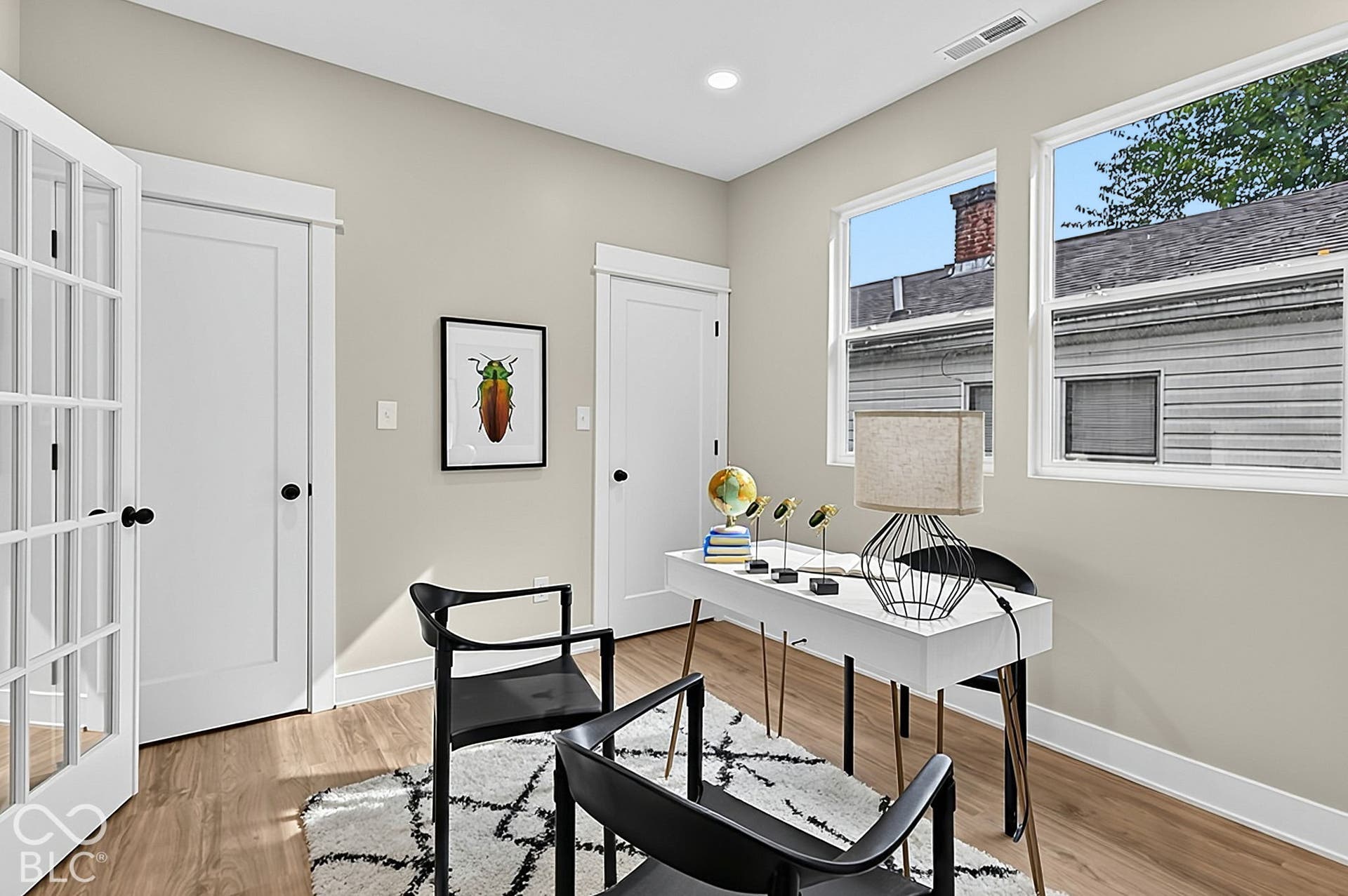 Wood-finish flooring, French doors with glass panes, dual-panel interior doors, and oversized windows