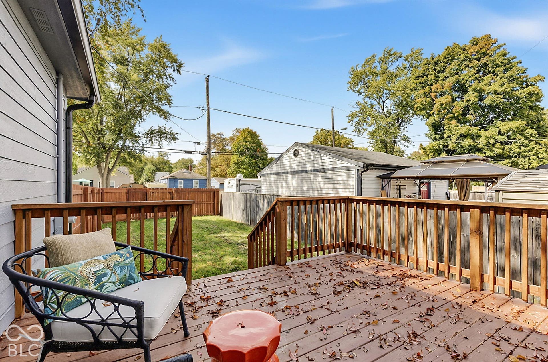 Elevated wood deck featuring vertical balustrades and a fenced backyard