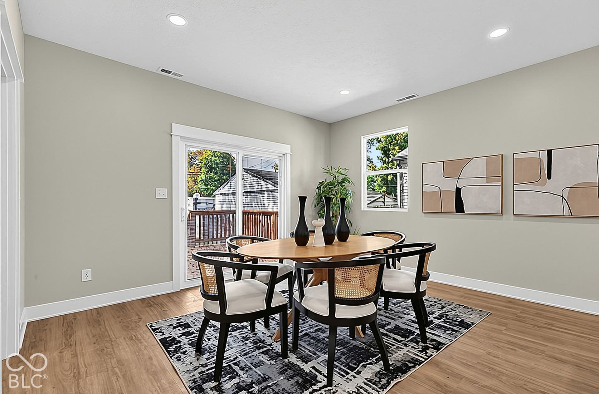 Neutral-toned interior featuring wood-finish flooring, recessed lighting, and a sliding glass door providing external access