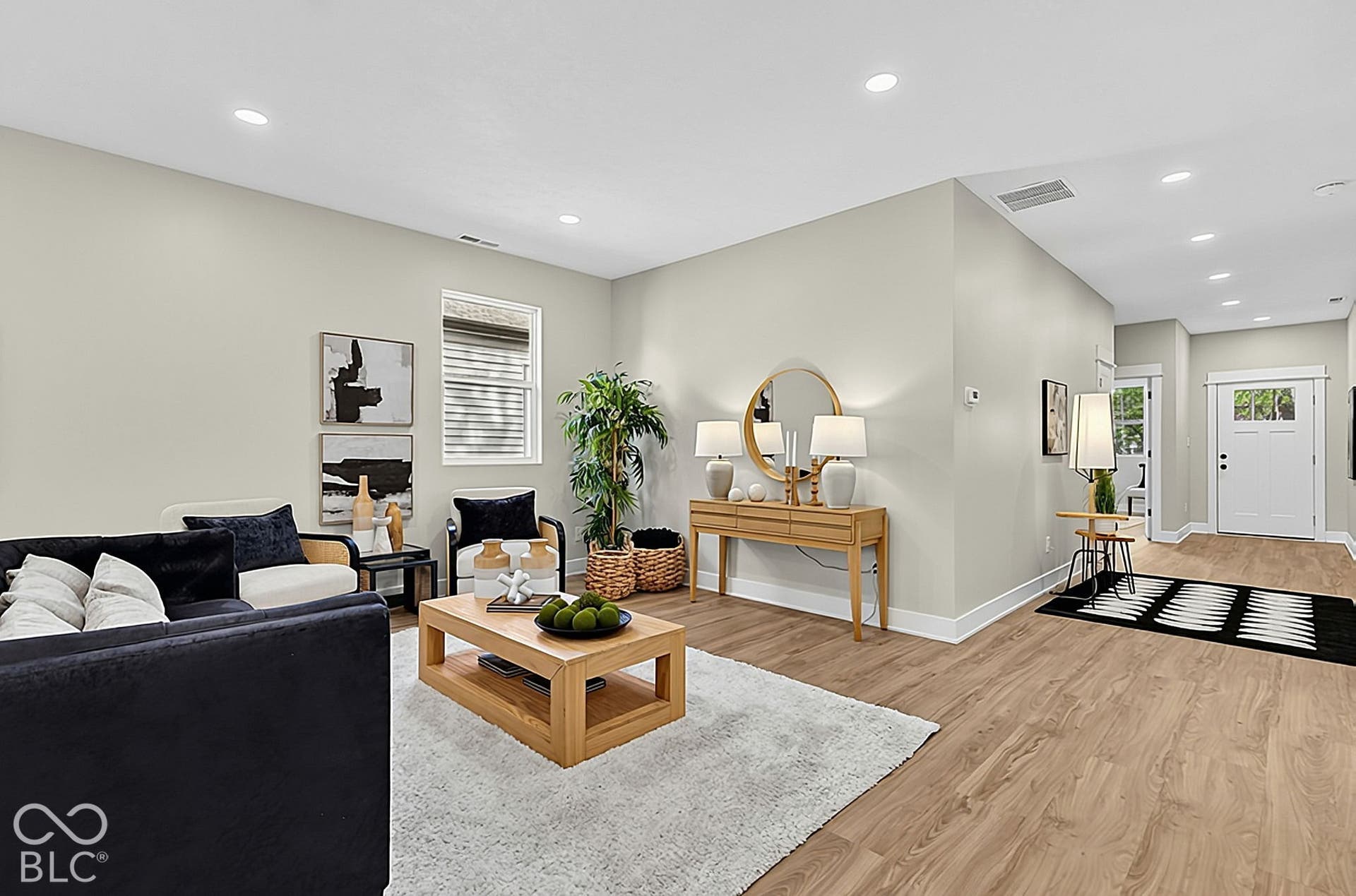 Neutral-toned interior featuring wood-finish flooring, recessed lighting, and a paneled entry door with window insets