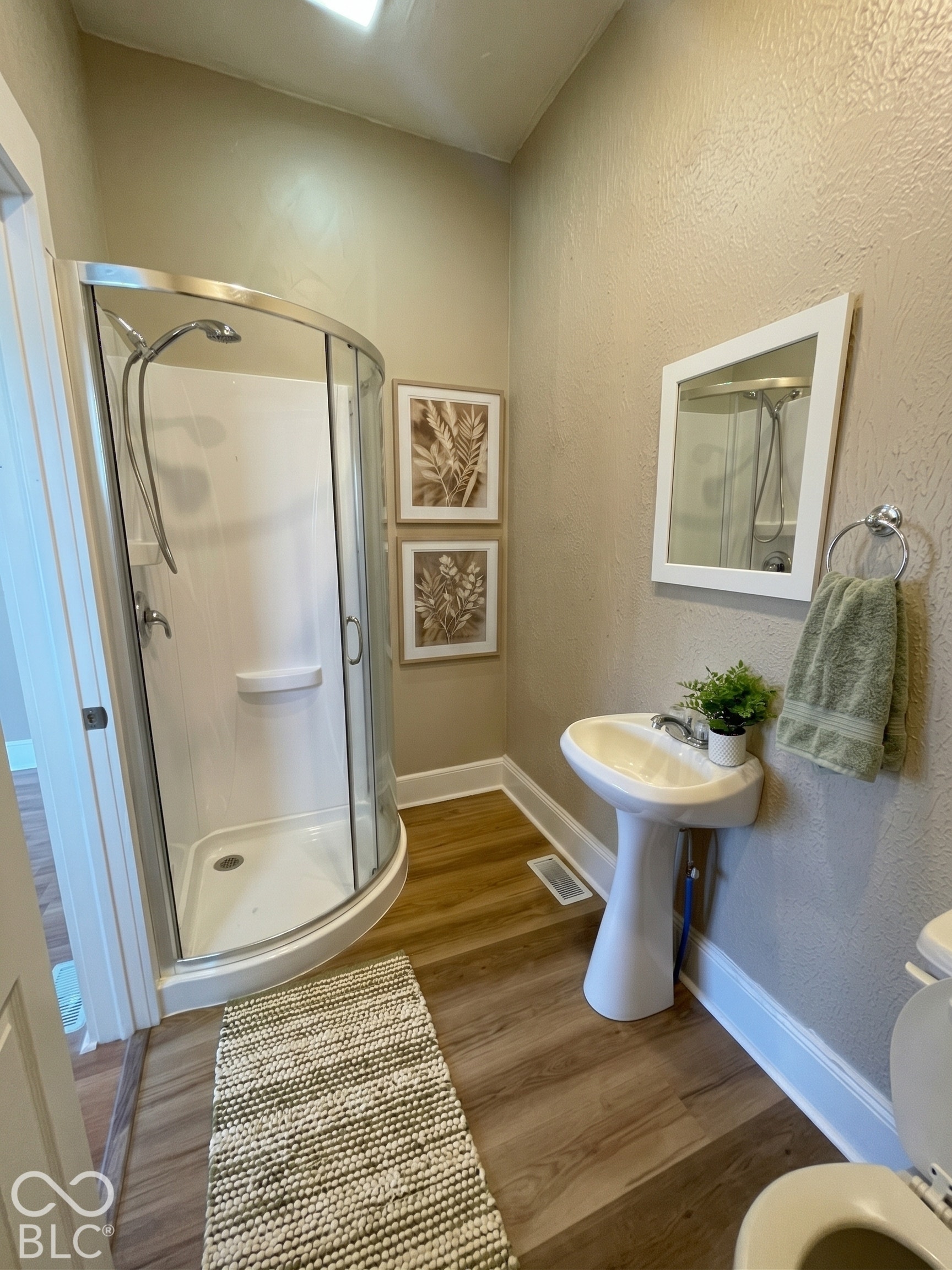 En-suite bathroom with a pedestal sink & shower stall.