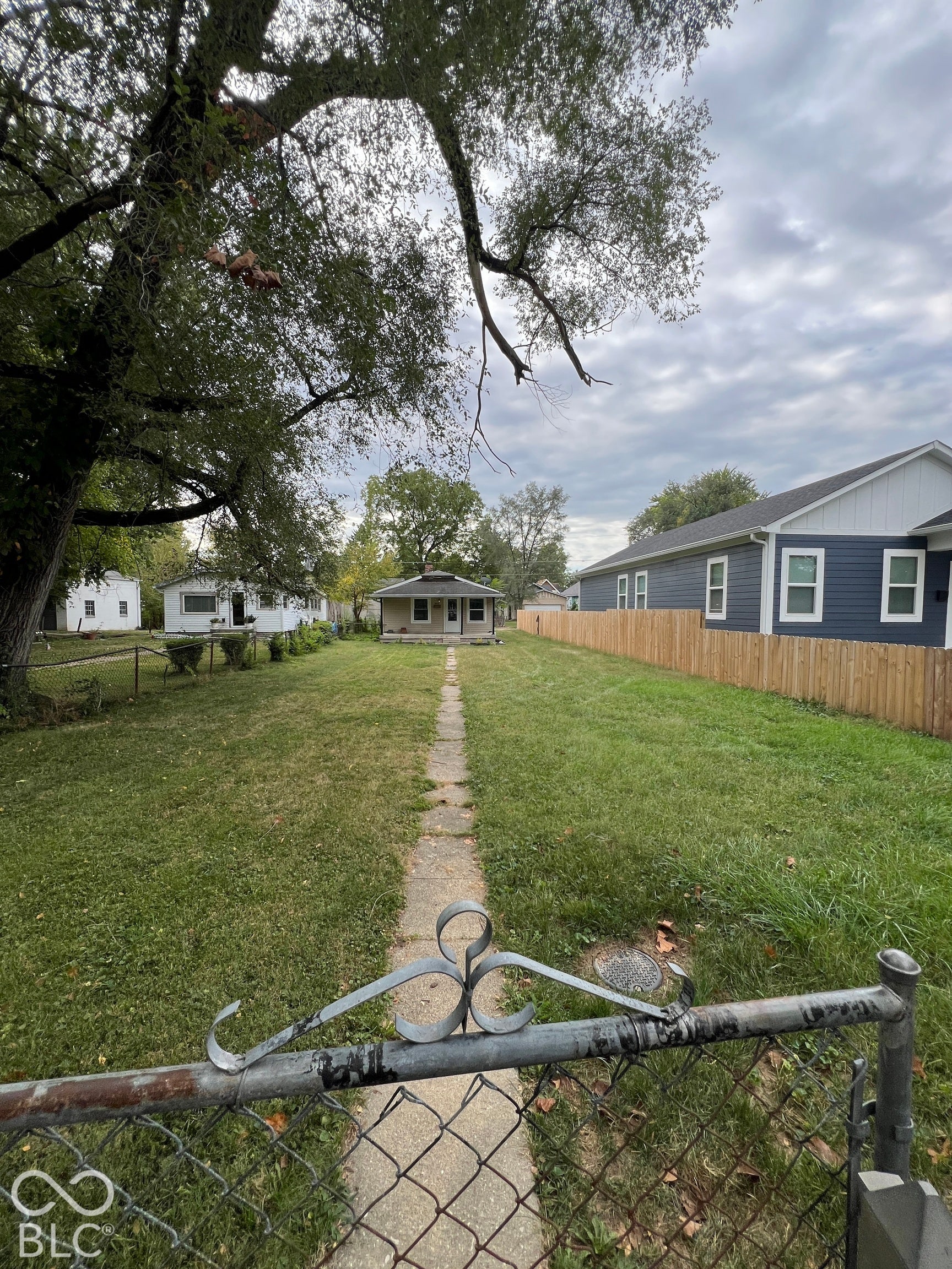 1431 W Pruitt Street, Indianapolis, IN 46208 Expansive front yard with a concrete pathway and chain-link fencing