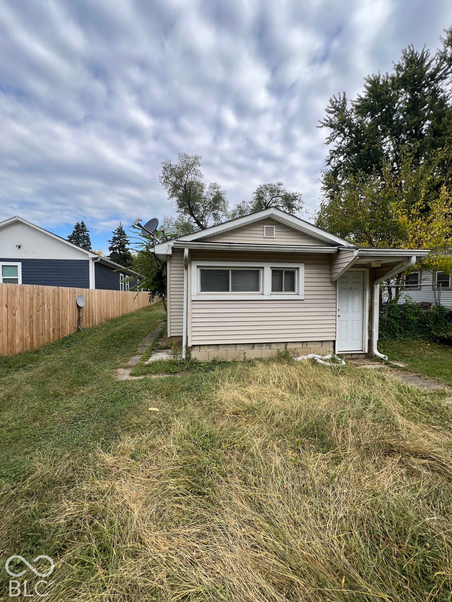 1431 W Pruitt Street, Indianapolis, IN 46208 Siding exterior with multiple windows, a white entry door, and an overhang