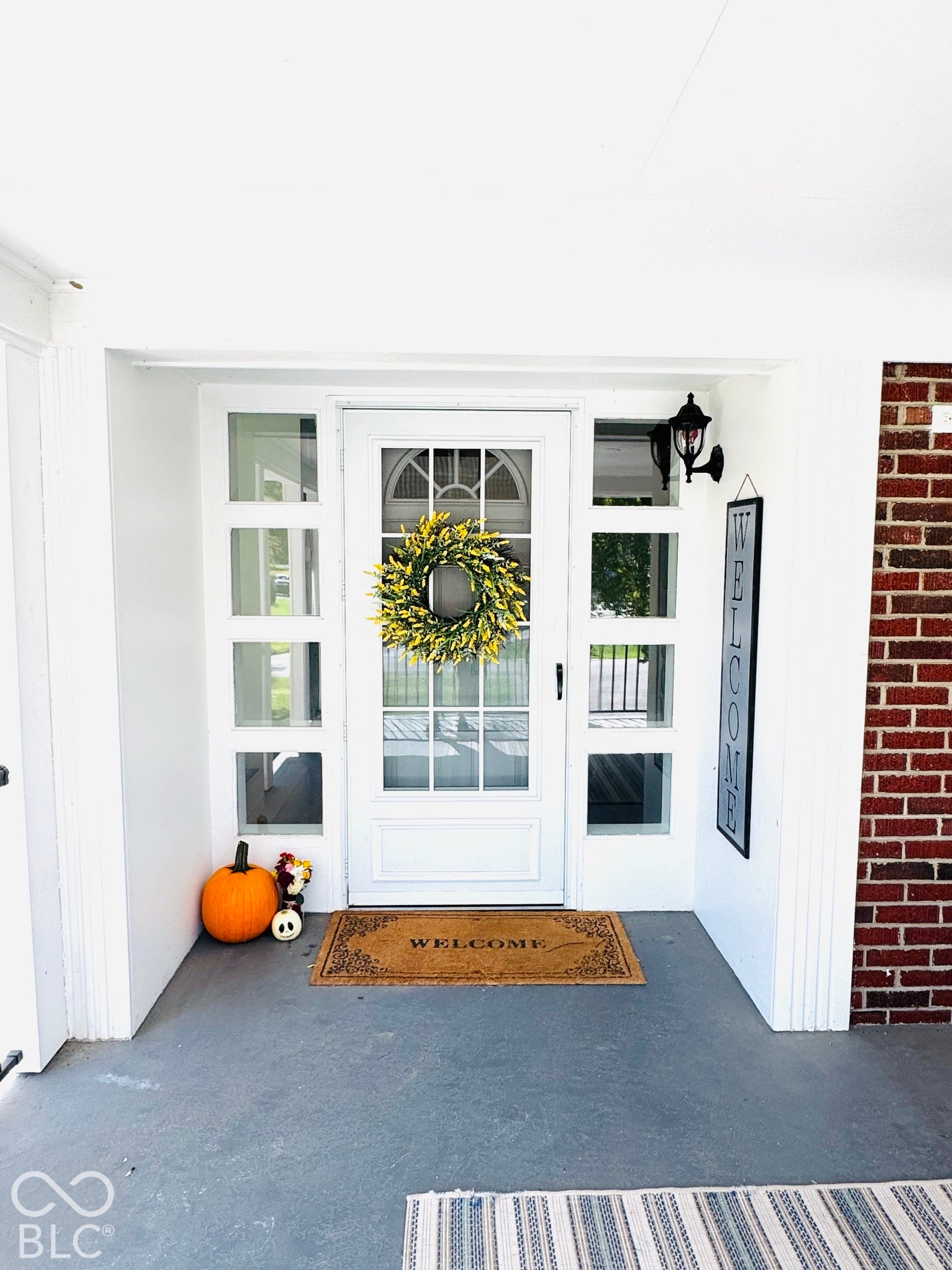 White entry door with arched upper lites and sidelite windows