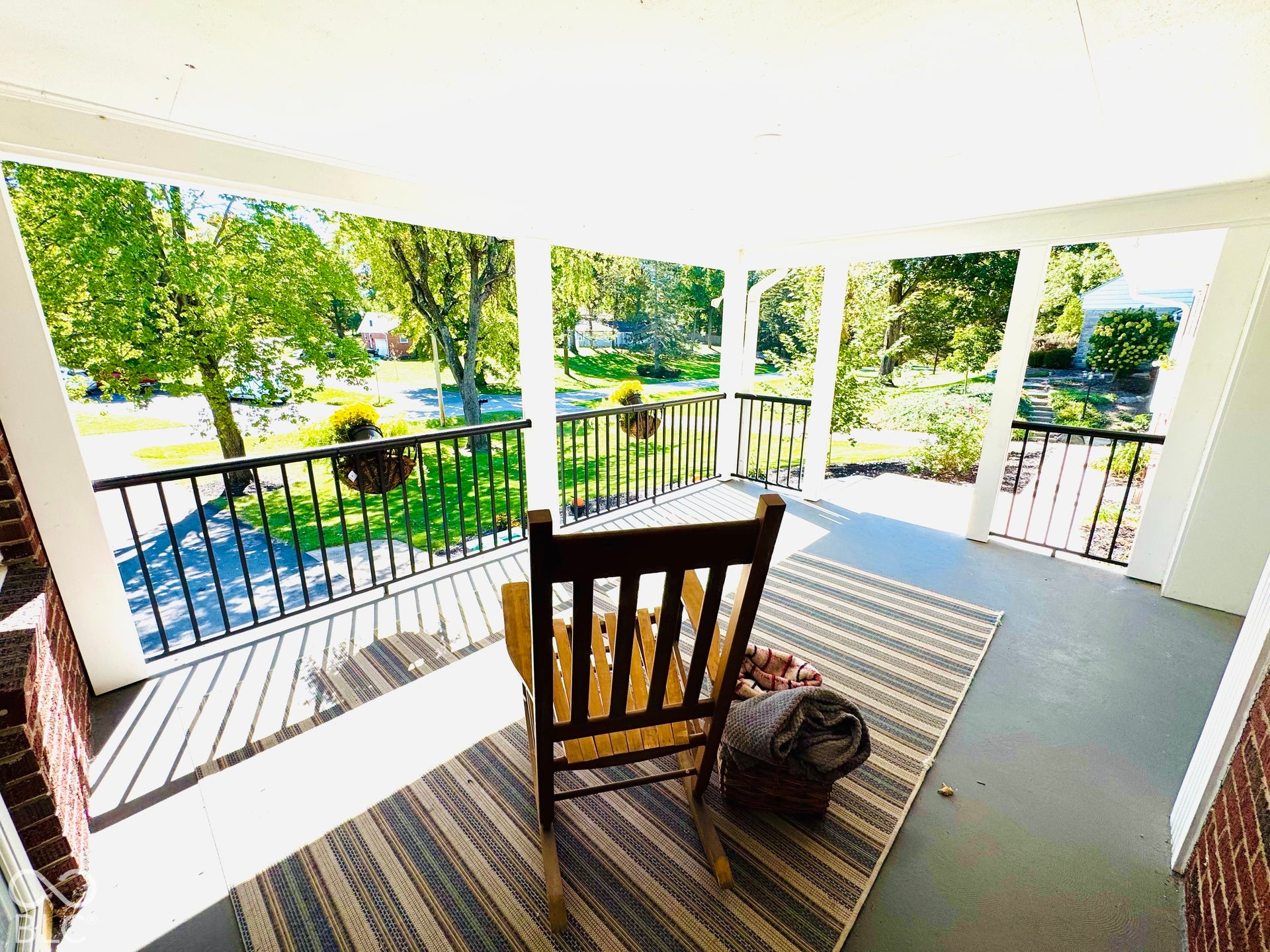 Enjoy everyday sitting on your Expansive covered porch featuring with white columns and black railing overlooking this beautiful yard