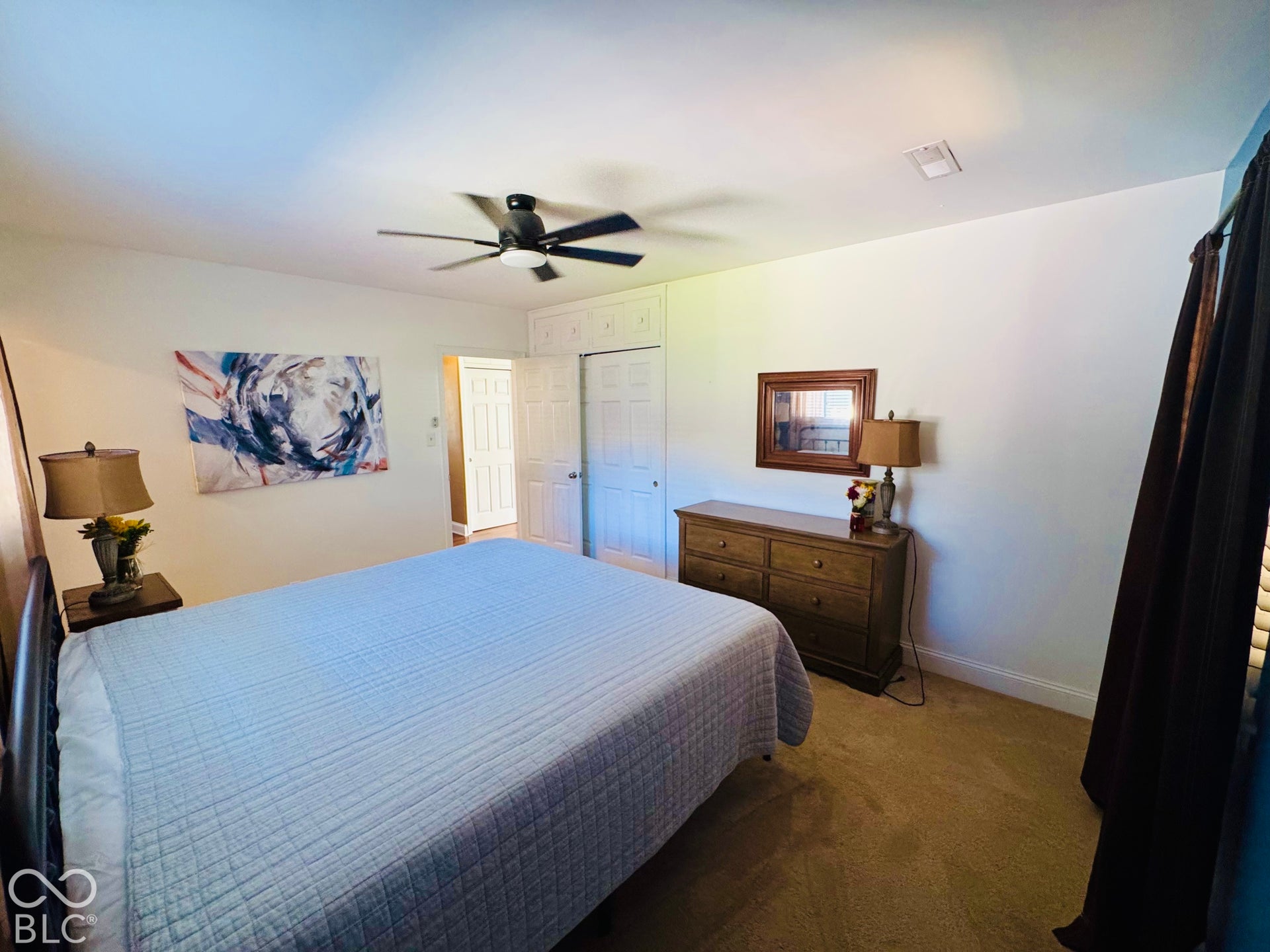 Ceiling fan with integrated lighting, built-in cabinetry, neutral wall paint, and plush carpet flooring