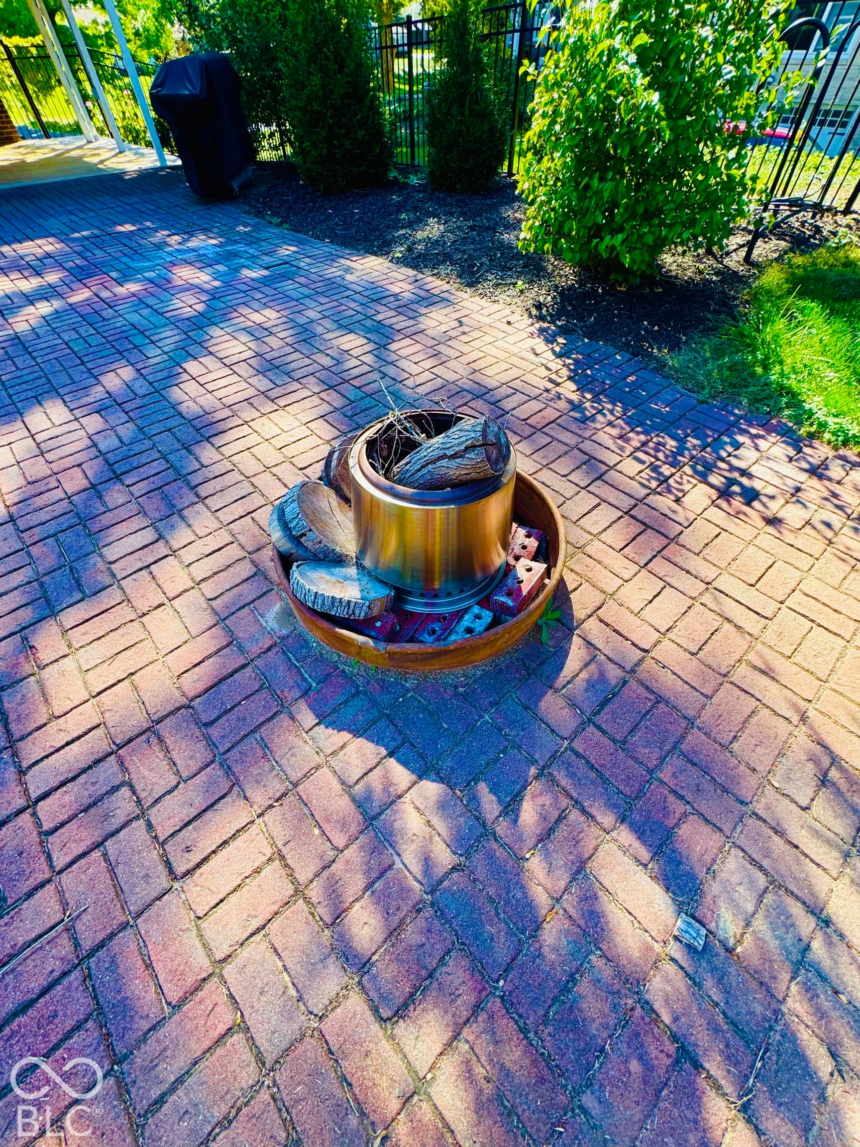 Enjoy the Firepit in this beautiful backyard.  Herringbone brick patio with lush perimeter landscaping and black wrought iron fencing