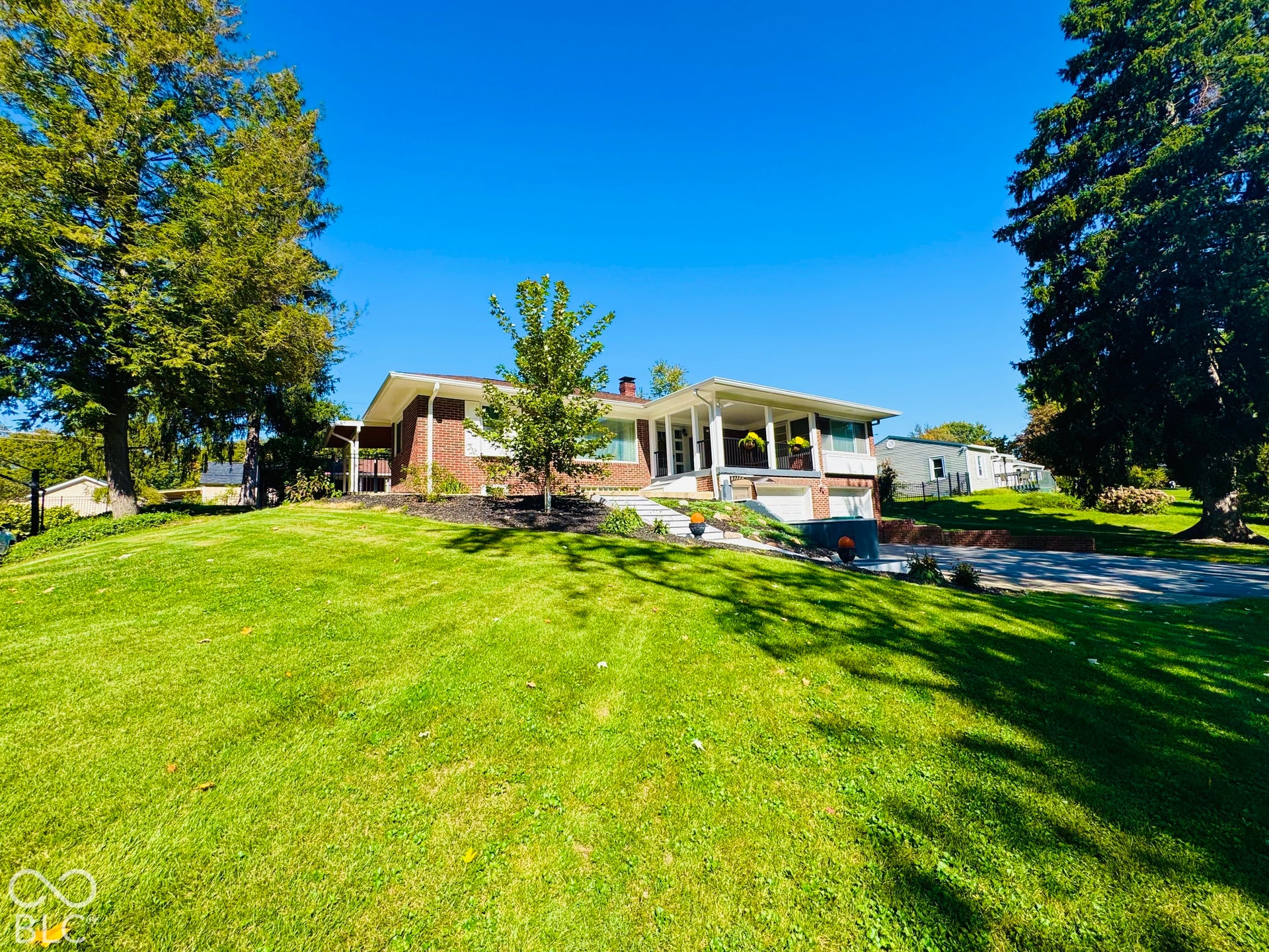 Brick exterior with white trim, covered front porch, and an attached garage