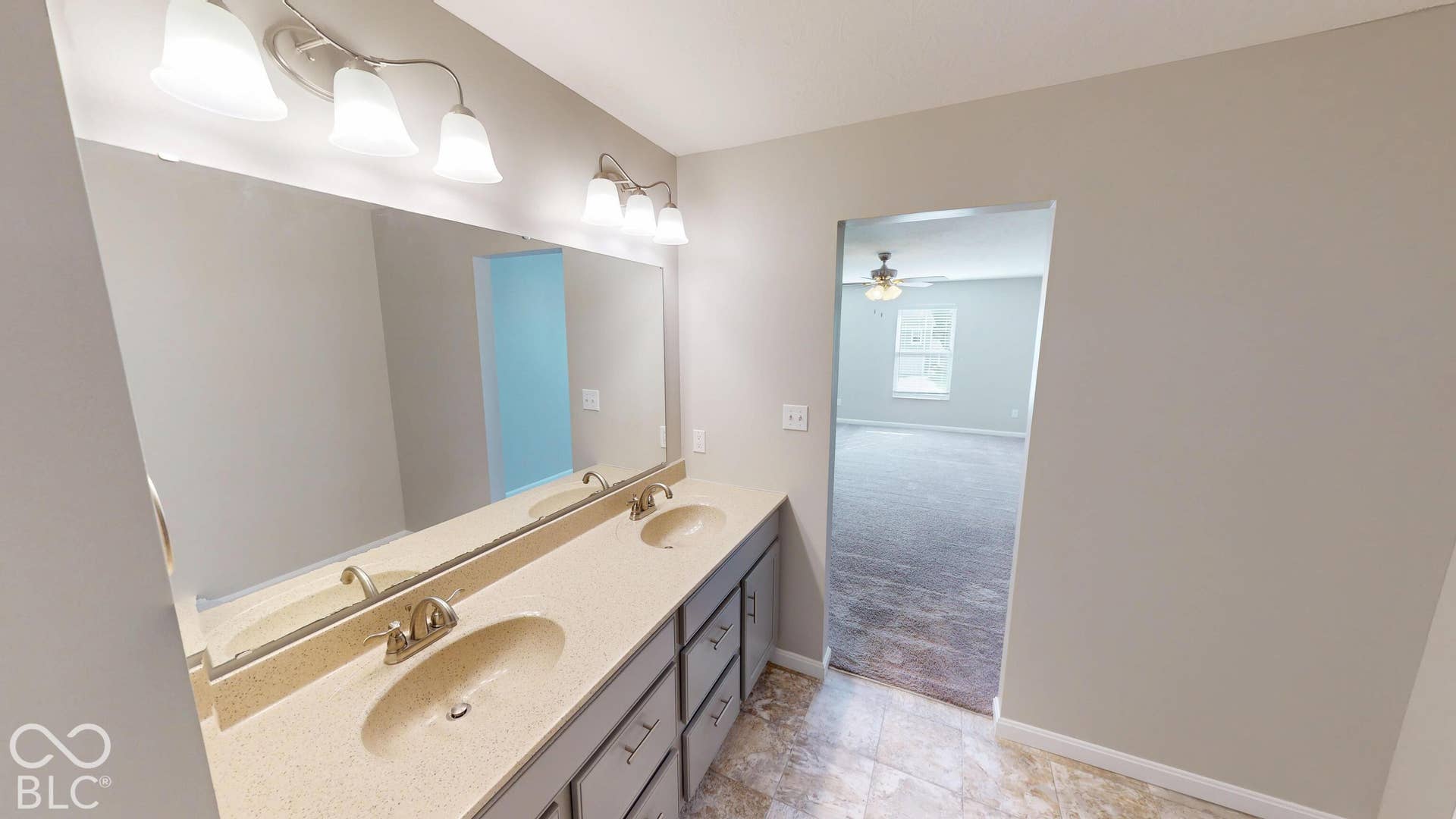 Double vanity with integrated sinks and brushed nickel faucets, set on a light-toned countertop