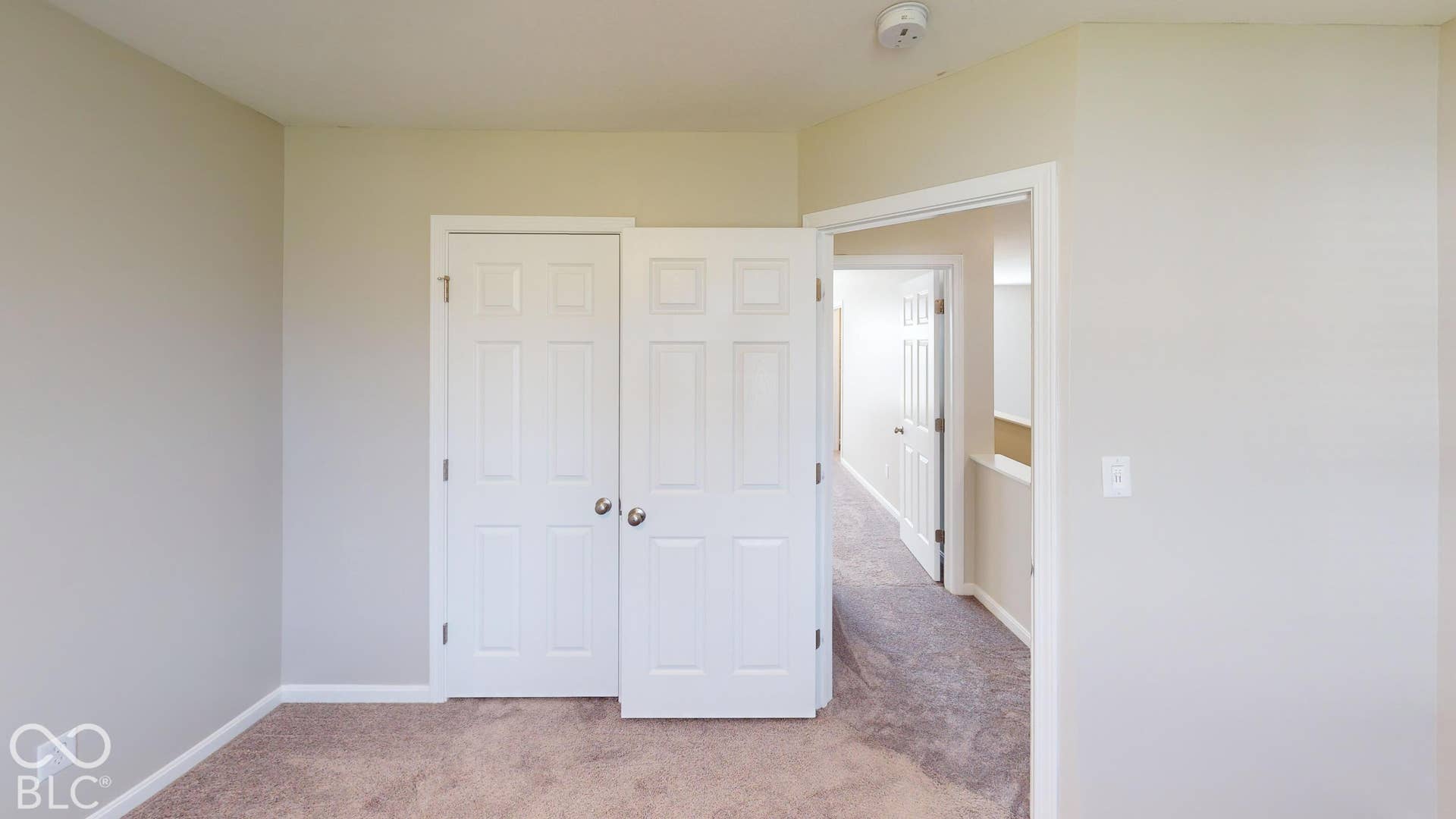 Bedroom # 1 | Plush carpet flooring, neutral paint palette, paneled interior doors, and a ceiling-mounted smoke detector