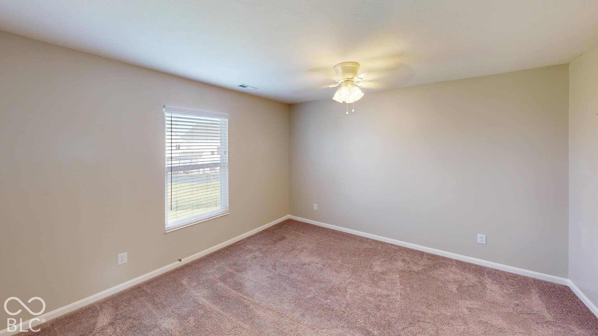 Bedroom #1 | Carpeted flooring, neutral wall tones, ceiling fan with integrated lighting, and a single window with blinds