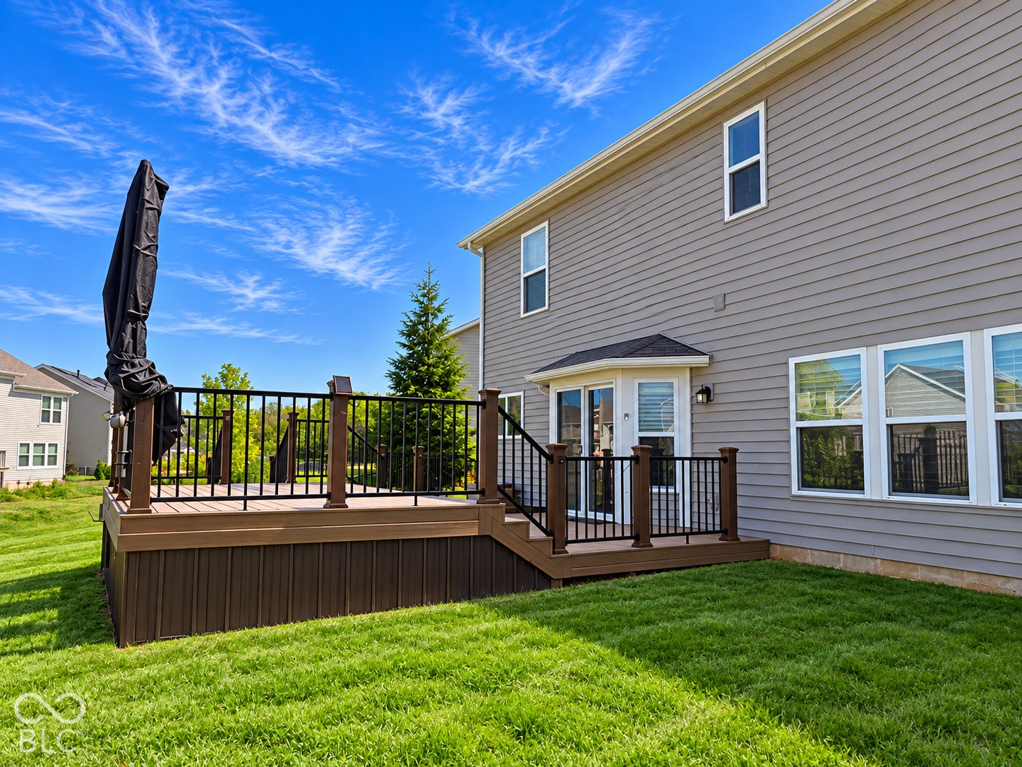 *AI - Color Enhancement* Outdoor deck with composite decking, black aluminum railings, and integrated steps