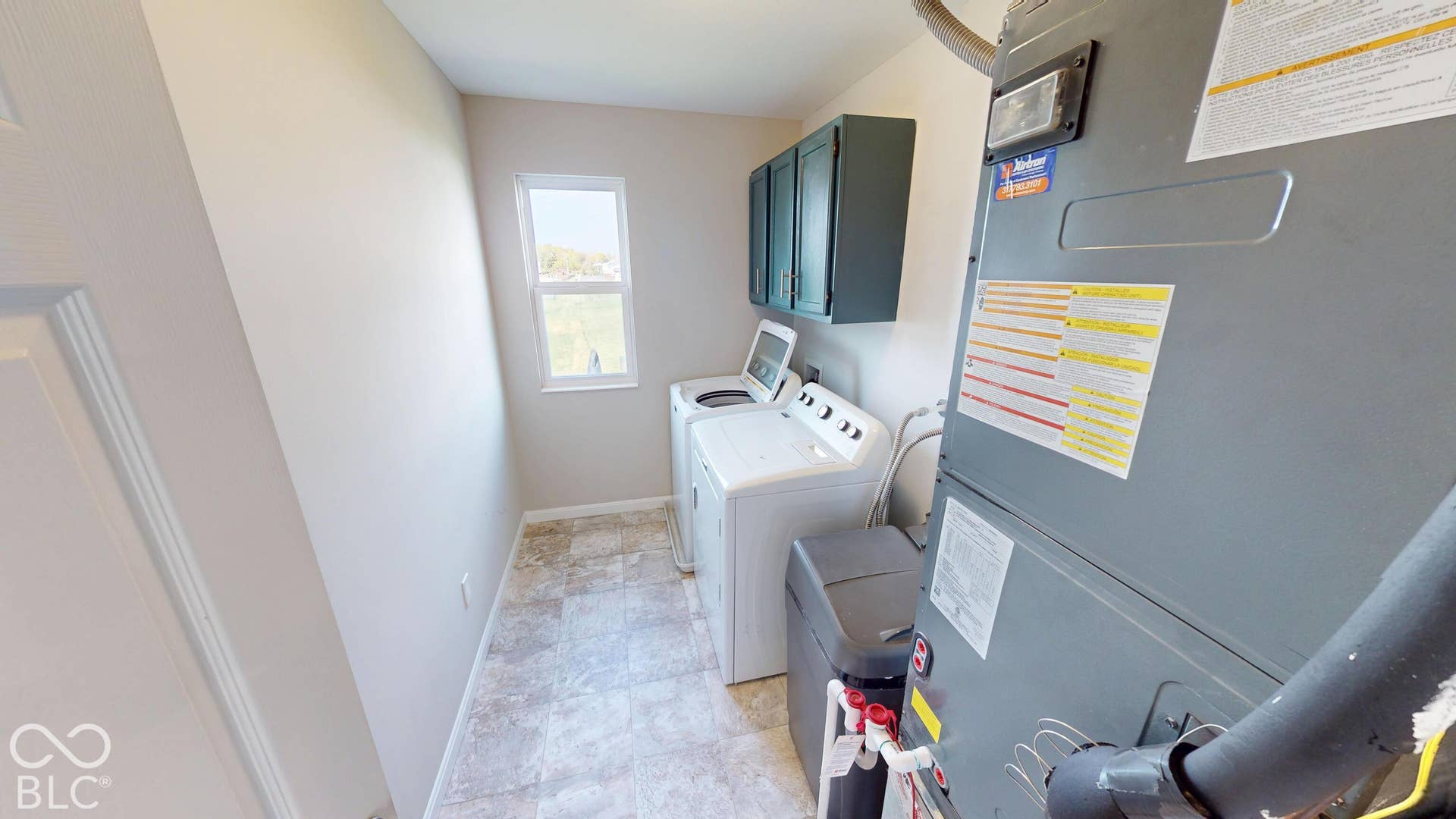Built-in upper cabinetry, single window, and light-toned flooring
