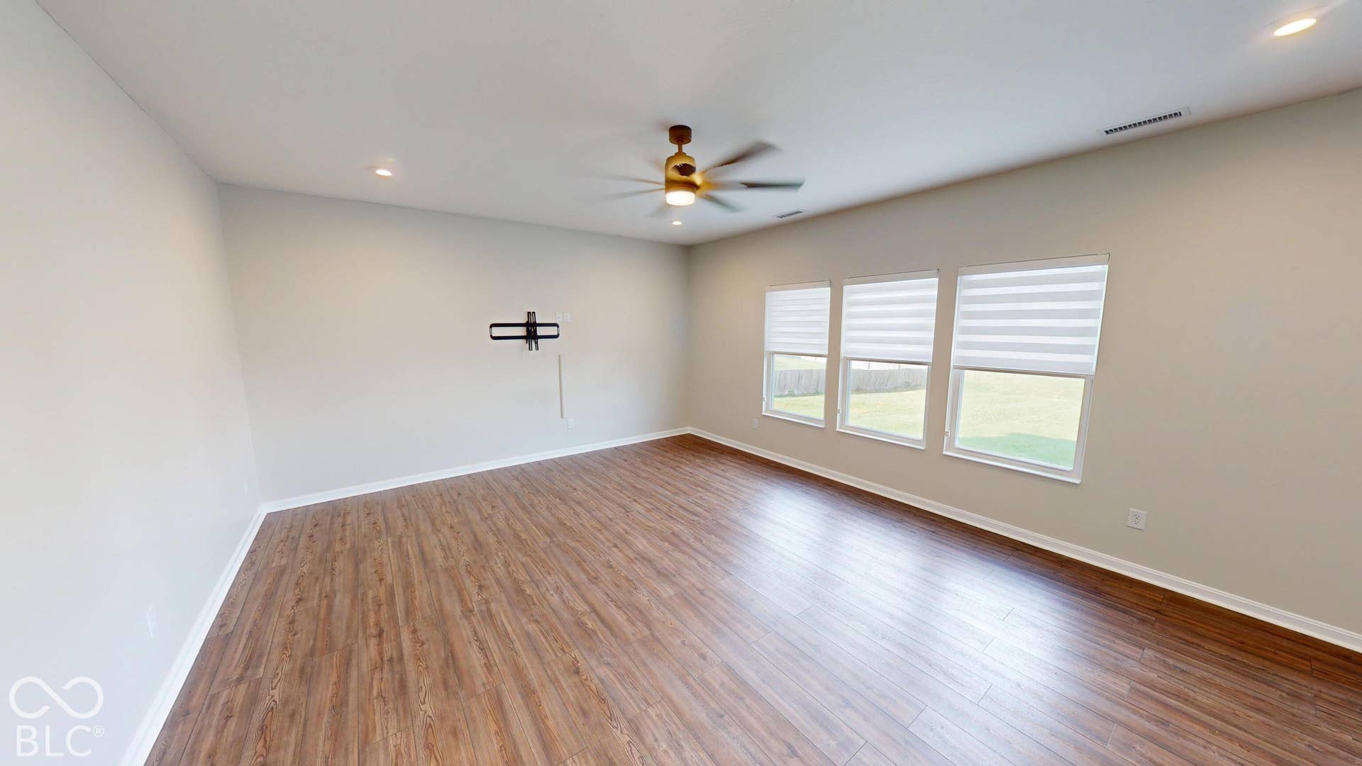 Wood-finish flooring, recessed lighting, and a ceiling fan with integrated light