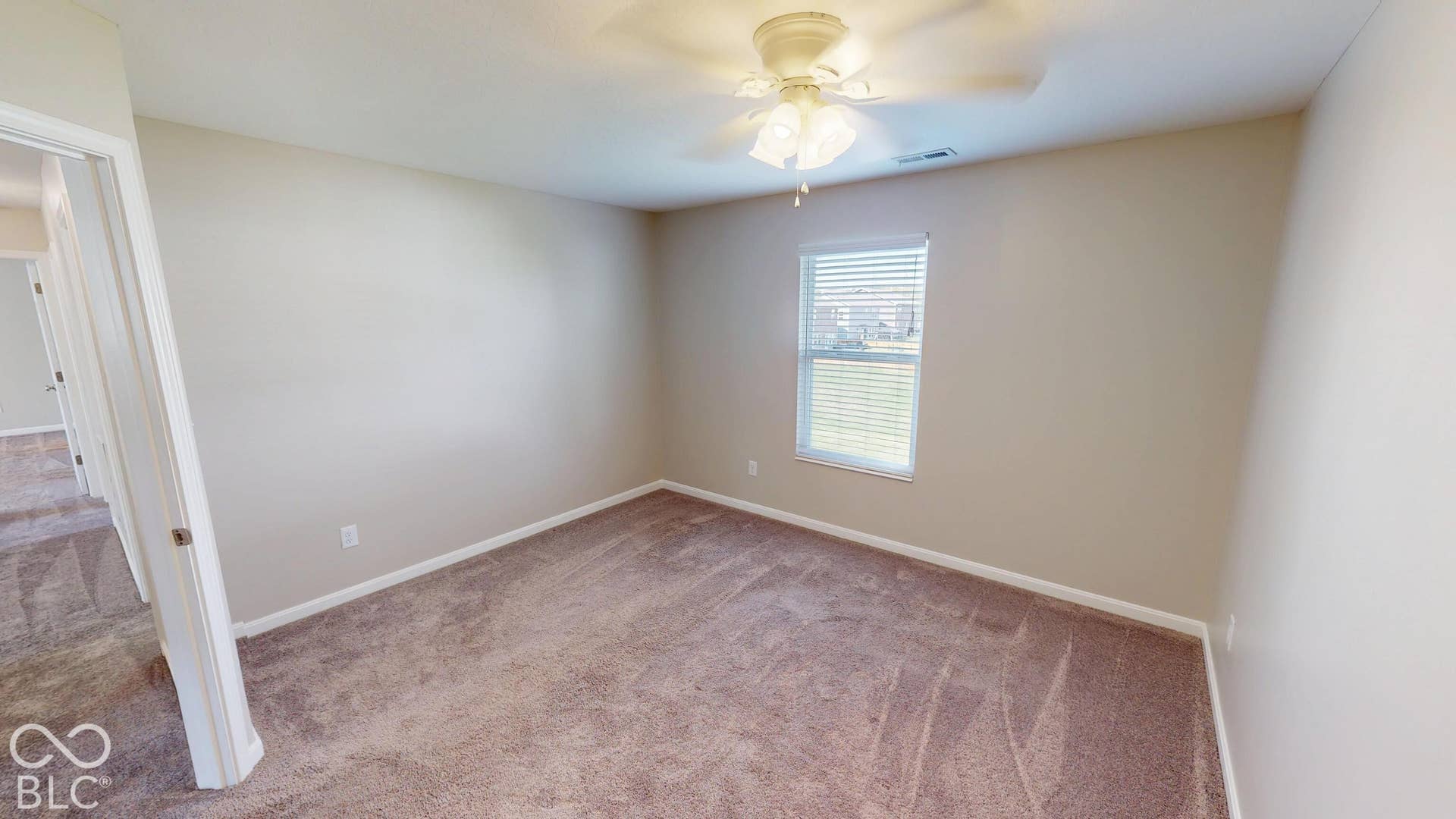 Bedroom #1 | Neutral-toned walls, plush carpet flooring, and a ceiling fan with integrated lighting