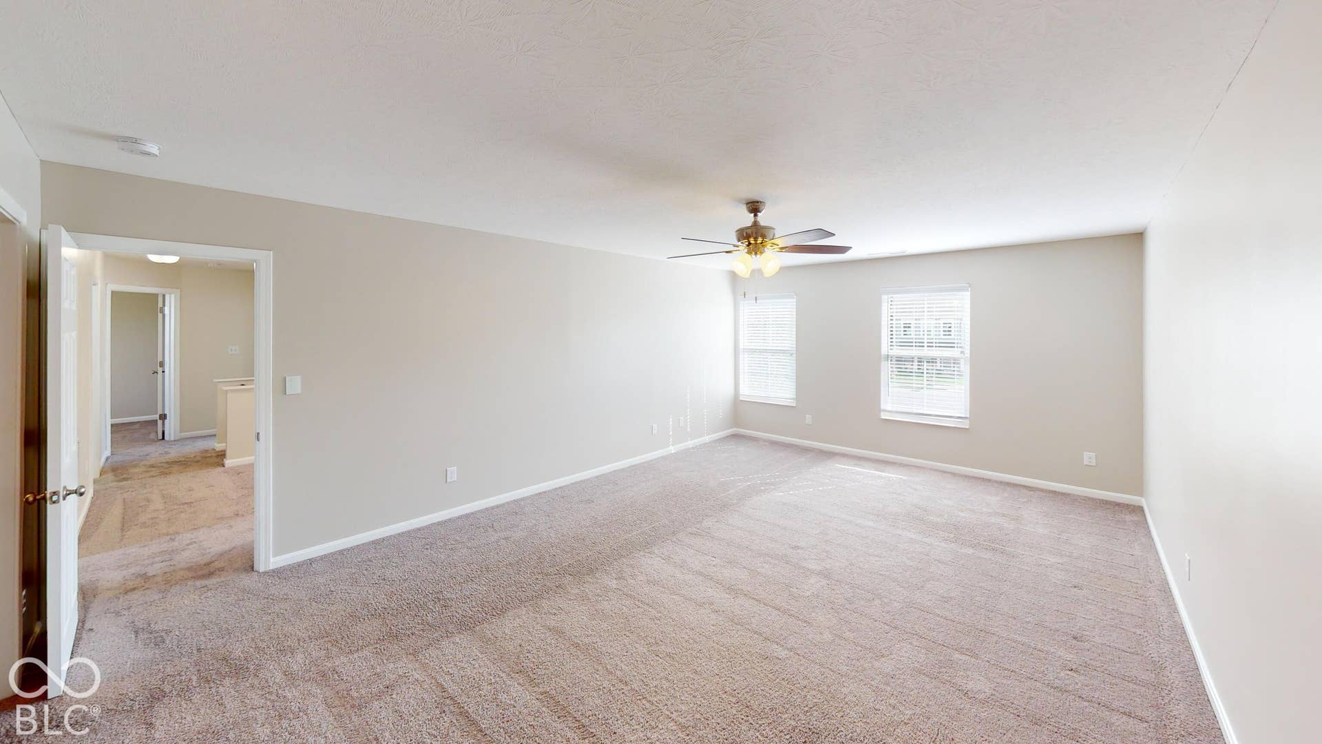 Bedroom # 3 | Expansive carpeted room featuring two windows, a ceiling fan with integrated lighting, and neutral wall tones