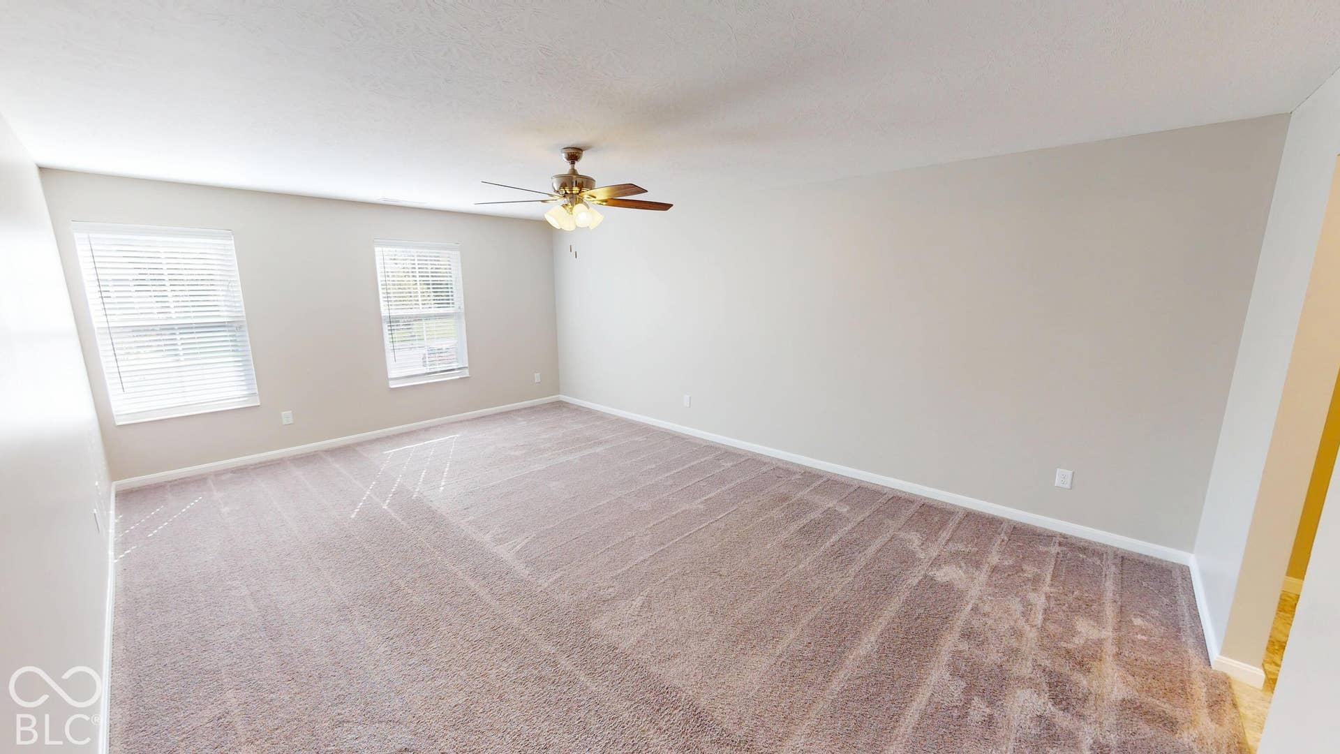Primary # 3 | Spacious room featuring neutral carpeting, light-toned wall paint, and two windows with blinds