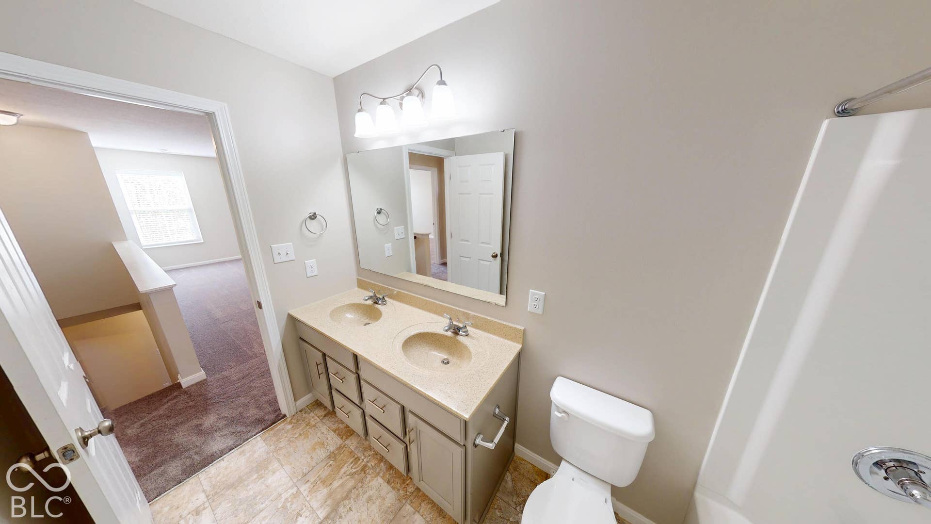 Double vanity with integrated sinks, framed mirror, and chrome fixtures