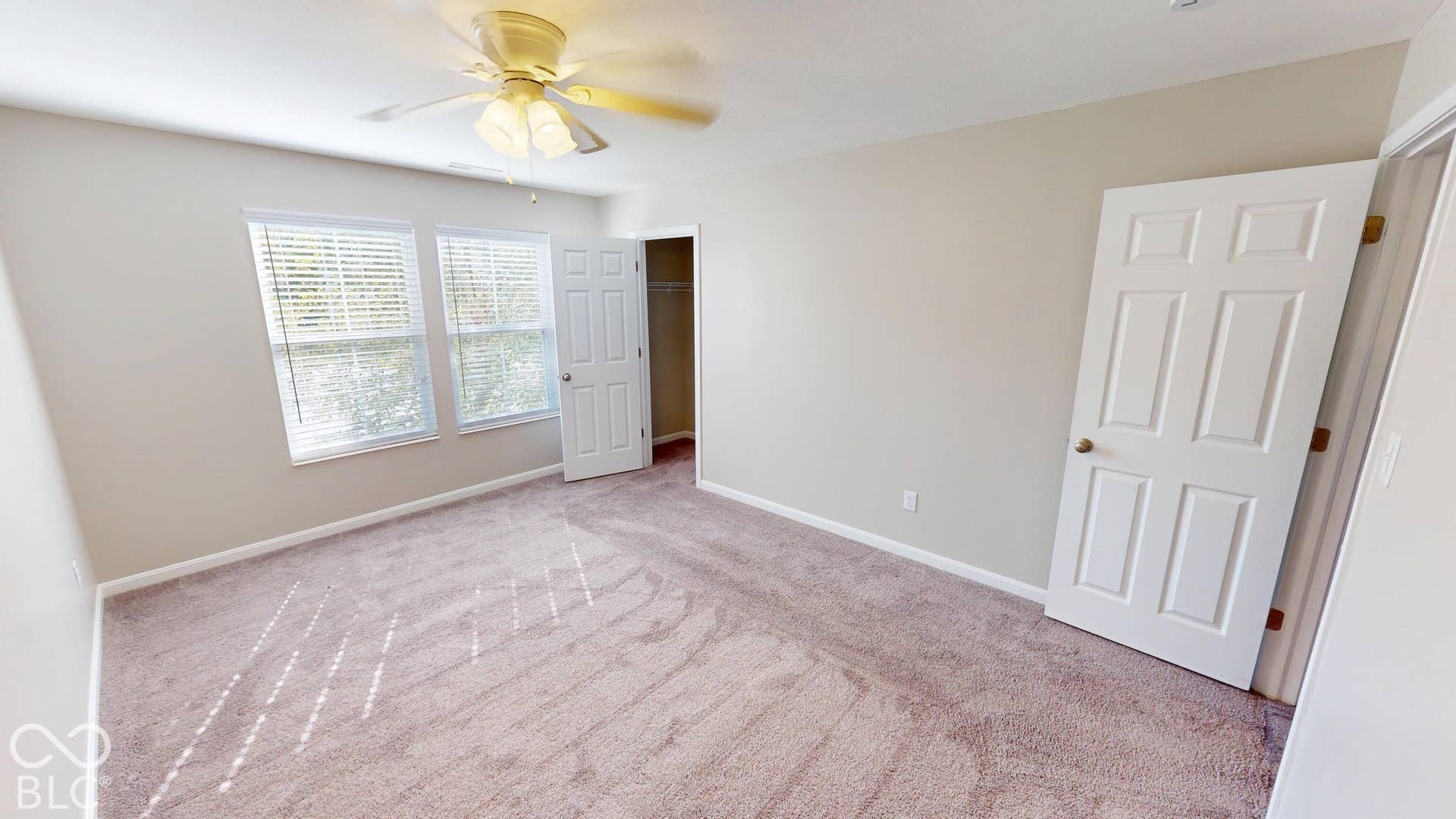 Bedroom #2 | Carpeting in a neutral tone, ceiling fan, and two windows with blinds
